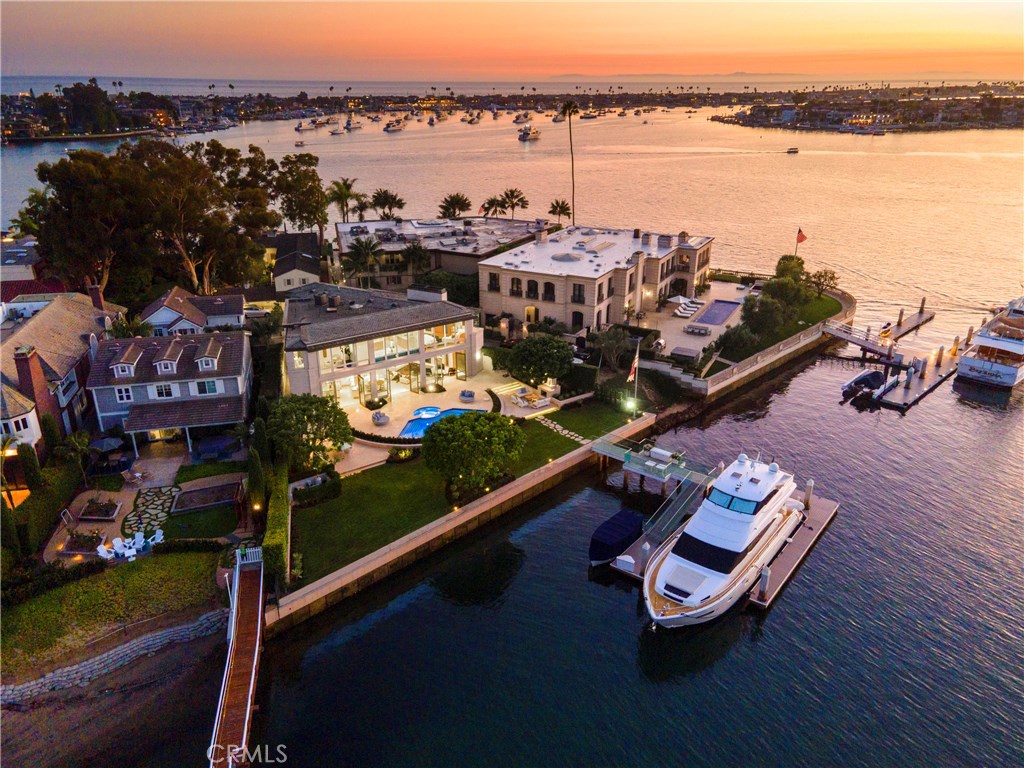 The exclusive, 24 hour guard-gated enclave of Harbor Island is perhaps the most coveted collection of waterfront residences in all of Southern California. 134 feet of linear water frontage with bayfront pool, an arboreal terraced garden, outdoor living space with fireplace, pool bath & outdoor shower all overlooking massive private dock to accommodate approx. 90-foot yacht, 70 ft. vessel, 58 ft and 35 ft. boats + option for larger vessels with dock reconfiguration. This soft contemporary design by architect C.J. Light is appointed with the finest details. Bathed in light, nearly every room is illuminated by expanses of glass that capture the views of the waterway and main turning basin. The main level, with a grand, yet comfortable elegance, encompasses multiple spacious venues for living, dining, and formal entertaining, including a kitchen fitted with specimen granite, Siematic cabinetry, and professional-grade appliances. The 2nd level, accessed by a dramatic staircase of glass, wood, and stainless steel, is balanced with light & views leading to 4 en-suite bedrooms, including a gracious master suite with views, wood-burning fireplace, marble, mirrored walls, dual vanities & privacy glass. Garage with lift for parking 3 cars, 6 additional dedicated parking spaces. Crestron home automation, Comfor Sync thermostat, video surveillance, automated blinds, lighting and remote pool controls. Exceptionally private and secure with accessibility to multiple international airports.
