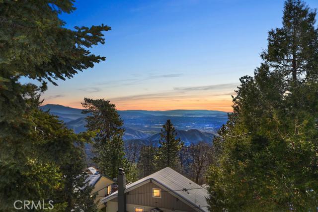 Come see this house on the hill! Enjoy this cozy home nestled in Rimforest California. It is level entry and has two bedrooms and two bathrooms. It sets on a large corner lot with absolutely astounding views of the valley! Great decks on both the front and off the upstairs bedroom. Wonderful wood floors in the living areas, and slate in the kitchen and bathroom. Wood burning stove. Also has a buildup area that can be used for storage or a small workshop, along with washer/dryer hookups.