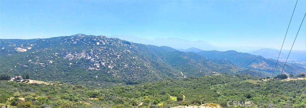 Adjacent to the expansive 1600-acre Mount Olympus nature preserve, this picturesque retreat is also a sanctuary for ringtails and other native species. Accessed via Sombrero, a private and paved road renowned for its luxurious estate homes, the property boasts waterways that flow through the valley, along with Gomez Creek and two additional streams originating from the east. The 85-acre expanse presents a wealth of possibilities, ideal for agricultural projects, an extensive equestrian facility, or a tranquil natural haven. The landscape is graced with towering oaks, sycamores, and gentle ridges flanking both the eastern and western sides of the valley. Essential utilities such as district water lines and power are already in place in the southwestern section. The area exudes a profound sense of tranquility, home to a variety of wildlife including deer, coyotes, foxes, eagles, hawks, and the occasional mouse. Tucked away in the serene Rainbow Heights, this enchanting valley offers endless potential and natural beauty.