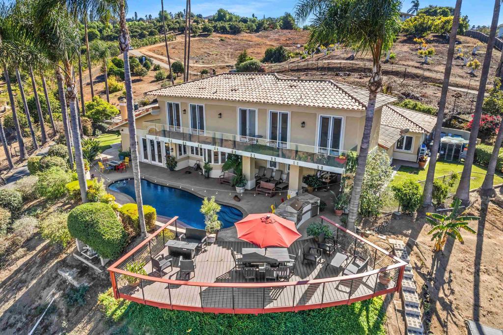 This expansive home sits on approximately 4.42 acres of lush, picturesque land. The five-bedroom, office, four and one-half bathroom residence encompasses approximately 4,750 square feet of livable space, offering an abundance of natural light and a spacious, open layout. The home features hardwood flooring throughout, complemented by modern appliances and ample cabinetry in the kitchen. Tile flooring can be found in select areas, providing a visually appealing contrast. Storage space is plentiful, with a walk-in pantry boasting over 100 wine bottle storage options. The outdoor space is truly breathtaking, with a spacious deck, patio and an inviting pool surrounded by lush vegetation and scenic views. The property also includes a four-car garage, a solar water heater and a central vacuum system. Technological features include 80 solar panels (40 owned and 40 leased), two Tesla chargers and an alarm system. The home also boasts Pella windows and French doors, as well as a heating and air conditioning system approximately three years old. The expansive lot features a variety of fruit trees, including lime, peach, guava, apple, plum, cherry, dragon fruit, persimmon, Asian pear and kumquat. The Haas Avocado grove was planted with 225 Hybrid Haas Avocado Trees for better water efficiency. The property also includes raised gardens and two chicken coops, although currently there are no chickens on the premises. This gated property is located in the Hialeah neighborhood, providing a peaceful and private living experience.