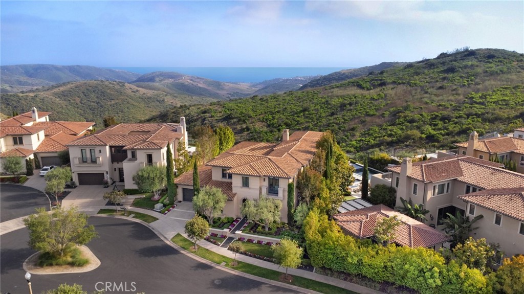 First time on the market this Fiano New Home Company Residence is located on 1/4 of an acre in the prestigious Pacific Ridge, an exclusive 24 hour guard gated community in Newport Coast. Built in 2016, this exquisite 5 bedroom, 5.5 bathroom residence has two primary bedrooms, one upstairs and one downstairs positioned with the best panoramic ocean views Newport Coast has to offer backing to open space with no neighbors behind.
Upon entering, you'll be greeted by high ceilings and floor-to-ceiling windows that bathe the interior in natural light, providing open, panoramic, and water views. The southwestern exposure ensures a constant influx of warm sunlight throughout the day.
With over 6100 sqft, this home offers a highly functional floorplan for your busy lifestyle. This open floorplan concept celebrates the gorgeous chef’s kitchen with quartzite countertops, top-of-the-line Wolf stainless steel appliances, a Sub-Zero refrigerator, a butler’s pantry located just off the kitchen, walk in pantry and a custom 1,000 bottle climate controlled wine room and formal dining.
The main floor primary suite overlooks the backyard with endless views and offers dual vanities, a soaking tub and two oversized closets conveniently opening into the laundry room. The spacious upstairs primary room offers gorgeous ocean views, dual vanities, soaking tub and separate shower and walk in closet.
Each bedroom is en suite, upstairs you will find a bonus family room/den that provides additional space for relaxation or entertainment and right outside the courtyard is your own private home gym.
Situated on over a ¼ of an acre, the outside boasts the perfect oasis for entertaining. Each detail was thoughtfully positioned to capture the stunning views. The sliding doors off the living room open to create a seamless outside inside space. Soak in your private hot tub or enjoy the warmth by the firepit.
Residents of Pacific Ridge enjoy an array of resort-like amenities including community pool, sport courts, fields and a playground, 24-hour guard gated security, close proximity to prestigious schools, pristine hiking/biking trails, world-class shopping and dining at Fashion Island Mall and Pelican Hill Golf Course.