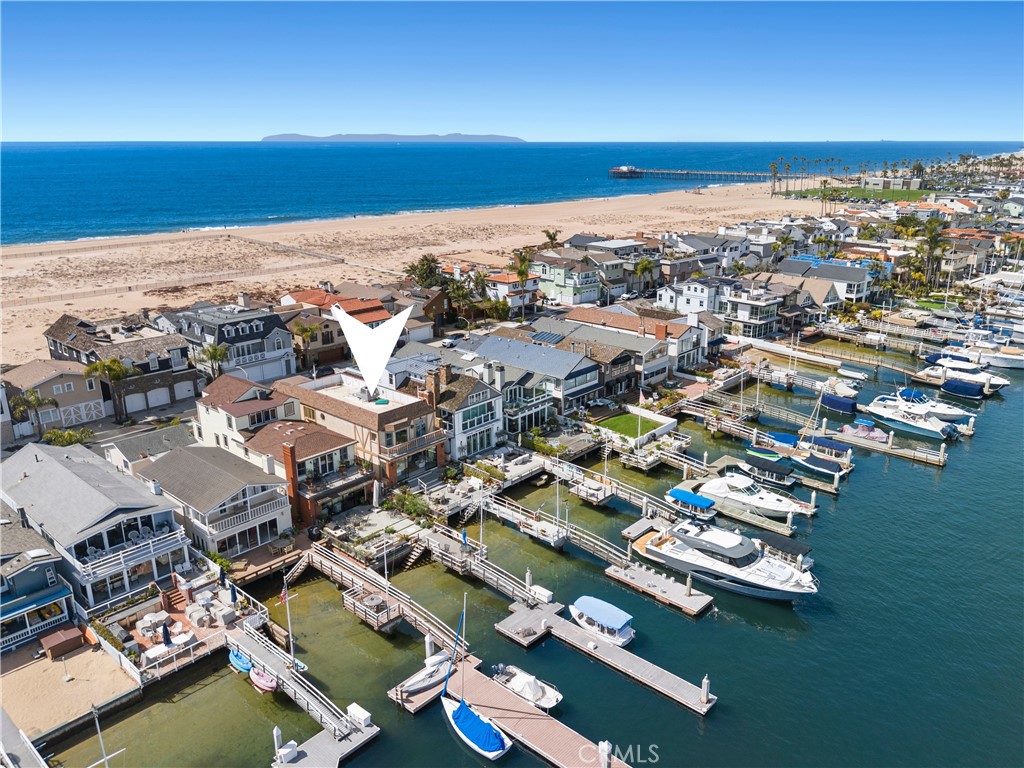 Situated on the coveted Newport Beach bayfront, 1214 E Balboa Blvd is four-bedroom, four-bathroom coastal retreat embodies luxury, comfort, and breathtaking waterfront views. The thoughtfully designed layout features a convenient downstairs bedroom and full bath just off the entry, perfect for guests or multi-generational living. Upon entering, you are immediately welcomed by a light-filled living room, where sliding glass doors open seamlessly to the expansive bayfront patio—an ideal space for entertaining, unwinding, and soaking in the stunning views of Newport Harbor. Upstairs, the master suite is a true sanctuary, complete with a cozy fireplace, a serene sitting area, a spacious en-suite bath, and sweeping panoramic views of the bay, all complemented by direct access to a private balcony. The second floor also boasts two additional bedrooms, a shared bathroom, a laundry room, and a generous back deck off the rear bedroom—perfect for sunbathing while enjoying a peek-a-boo view of the ocean. Just steps from the sand, this exceptional home also features a private dock and pier, providing direct access to the bay for boating, paddleboarding, and the ultimate waterfront lifestyle.