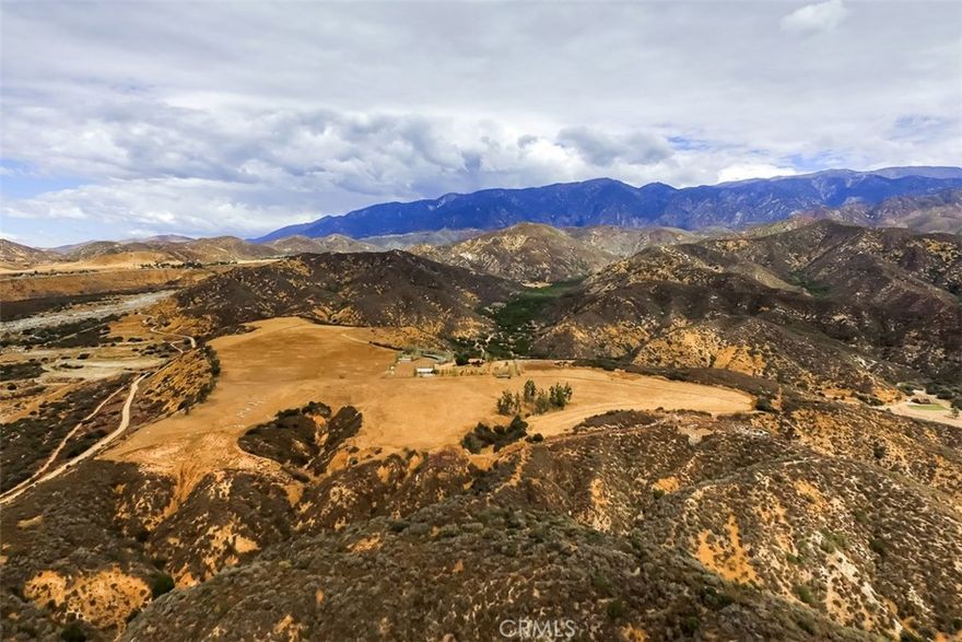Almost 100 acres on secluded mountaintop range overlooking the Banning Bench Area with 360 degree views. Incredible views from all directions and ultimate privacy for someone looking for space but still close to everything. Gated compound adjacent to the San Bernardino National Forest. Plenty of space for all of your toys and animals. Find peace, quiet and relaxation where the home sits overlooking the valley. Main house is 1779 sq ft 2 bedroom 2 bath home with an open floor plan and vaulted ceilings. Other structures including a barn and with stalls and a bedroom, a bathroom, big kitchen, ranch workers and endless possibilities. Chain link fence surrounds entire property with areas for the animals. 100' round pen, 50' bullpen and 20+ corrals / stalls and more. There are many fruit trees and other trees along the fence line. Miles of trails for walking and horseback riding. Ride through the trees and adjacent canyon with streams. Approximately 80% flat and useable and property is next to federal land / mountains. Custom barn accommodates a full size apartment for trainers with kitchen and living spaces. This property sits above the canyon and is truly unique. A must see!