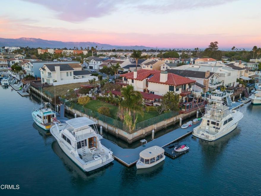 This truly one-of-a-kind residence in the heart of Channel Islands Harbor is curated for those who appreciate the finer things in life. Here you'll find a rare corner point home, a testament to luxury living and the iconic Southern California coastal lifestyle. Featuring 3 bedrooms, 3 bathrooms, and a sprawling 4,138 square feet of meticulously designed interior space, it's set on an expansive double lot of more than 12,000 square feet including the corner lot, ensuring privacy and limitless potential. An avid boater's dream, this home features massive boat slips measuring an impressive 130' and 135'. Outdoor spaces include a summer kitchen, outdoor shower, terraces, and greenspace, all with stunning waterfront views, offering an idyllic setting for outdoor living, gathering, and entertaining. Interior design details include Spanish tile flooring, stone fireplaces, skylights, custom cabinetry, exposed-beam ceilings, and sophisticated fixtures and finishes. Open-concept main floor living space includes a showstopping bar, walls of windows, custom millwork, and an expansive kitchen with a butcher block-topped center island, serving bar, and adjoining dining space. Fabulous owner's retreat features a walk-in closet, huge en suite bath, wet bar with beverage fridge, and a spacious sauna. Nestled midway between bustling LAX and the serene beauty of Santa Barbara, the setting offers coastal weather that complements the minutes-away access to the beach. Seamlessly transition from land to sea, boating to nearby restaurants, yacht clubs, or the enchanting Channel Islands.