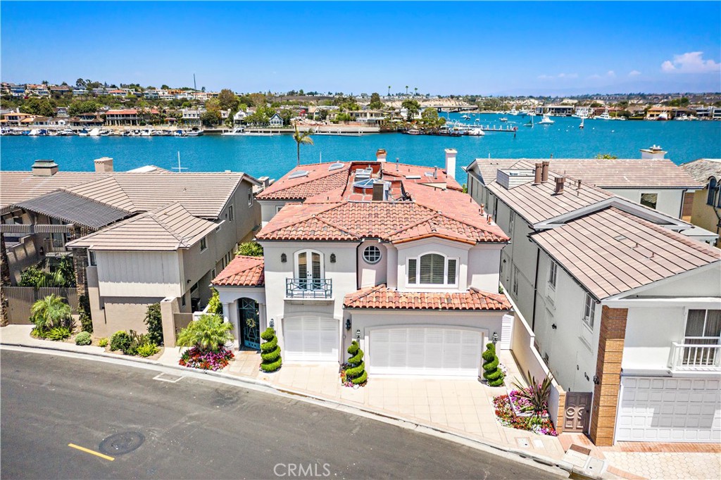 Rarely does an opportunity come along to own a prime bay front residence on stunning Lido Isle. This treasured, 5950+ sf family home, offering five bedrooms and five-and-a-half baths is a unique opportunity to own one of the most coveted lots on the island. Boasting breathtaking harbor views and panoramas from Saddleback Mountain to Laguna, this home’s location at the eastern tip of Lido is second to none. Extensively rebuilt as nearly new construction in 1991 on a 5600 square foot lot, this residence includes 50 feet of bay frontage and a slip that accommodates a 65-foot yacht, as well as two outside docks – plenty of room for your own personal fleet! Lovingly built in a modern Mediterranean style, this home presents an ideal opportunity to create your dream house right on the water. The first floor features a large living room with fireplace, formal dining room, family room, spacious kitchen, a wine cellar, a downstairs en suite bedroom and a distinguished library with cherry wood paneled walls and coffered ceilings and fireplace. The second floor offers four en suite bedrooms, including two generous primary suites with bay front views, fireplaces and spacious bathrooms and closets. Special touches include an elevator, spacious three-car garage with tons of storage, a gated entryway with fountain, and a spa overlooking the bay. The charming community of Lido Isle includes unique amenities for its residents - private tennis courts, parks, and its storied yacht club – and is sited just moments from the upscale dining and shopping at Lido Village. With a fantastic location facing Newport Harbor's main turning basin and unparalleled water and mountain views, this residence is an entertainer’s dream and presents the opportunity to own and cherish an extraordinary bay front home for generations to come.