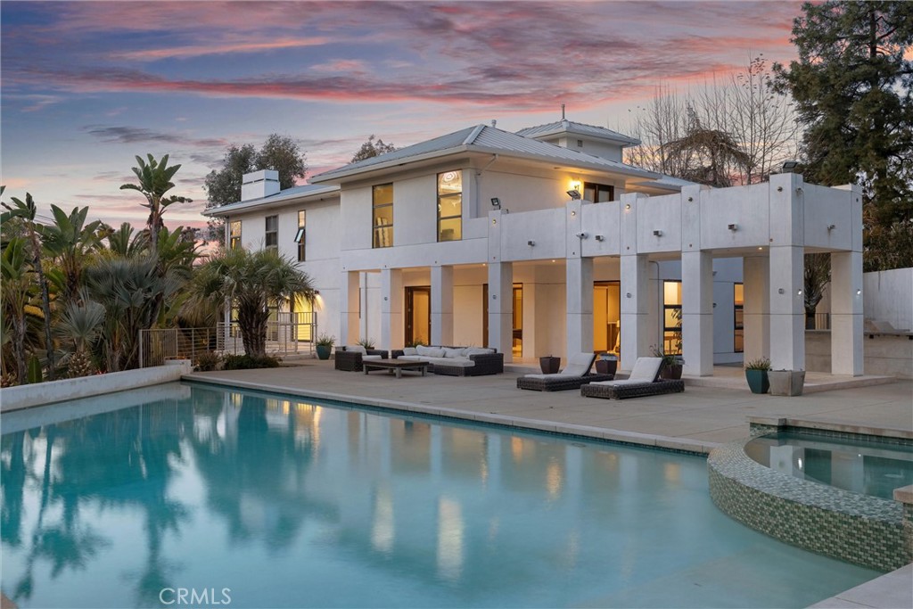 Exquisite Gated Architectural Estate in Prime Tarzana – A Luxury Lease Opportunity. Step into unparalleled luxury with this magnificent gated estate in the heart of Tarzana. Designed for the most discerning tenants, this architectural masterpiece seamlessly blends timeless elegance with contemporary sophistication. Beyond the private gates, a grand motor court sets the tone for an extraordinary living experience. The impressive double-door entry opens to a breathtaking two-story foyer, adorned with a custom chandelier, a skylight, and exquisite limestone flooring. The formal living room, with its stately fireplace, flows effortlessly into a banquet-sized dining room—ideal for lavish entertaining. The expansive family room, featuring another fireplace, connects seamlessly to the gourmet kitchen, which boasts top-tier appliances, a sunlit breakfast area, and a walk-in pantry. For entertainment, the home offers a game room with a pool table, a stylish wet bar with patio access, and a dedicated media room. A private library/office with its own bath and a well-appointed guest suite complete the main level. Upstairs, each en-suite bedroom provides an oasis of comfort and privacy, while the lavish primary suite is a retreat unto itself, featuring a spa-inspired bath, dual walk-in closets, and a private balcony. An elevator ensures effortless access to all levels, including the 6+ car garage, a rooftop deck, and multiple balconies with stunning views. A maid’s quarters and a state-of-the-art security system further enhance the home’s exclusivity. The resort-style backyard is an entertainer’s paradise, showcasing a spectacular infinity pool and spa, an outdoor fireplace, a fully equipped barbecue area, and lush grassy spaces—all set within the privacy of dual gates.
This extraordinary estate offers the pinnacle of luxury leasing in one of Tarzana’s most prestigious neighborhoods—ideal for those seeking an unmatched living experience.