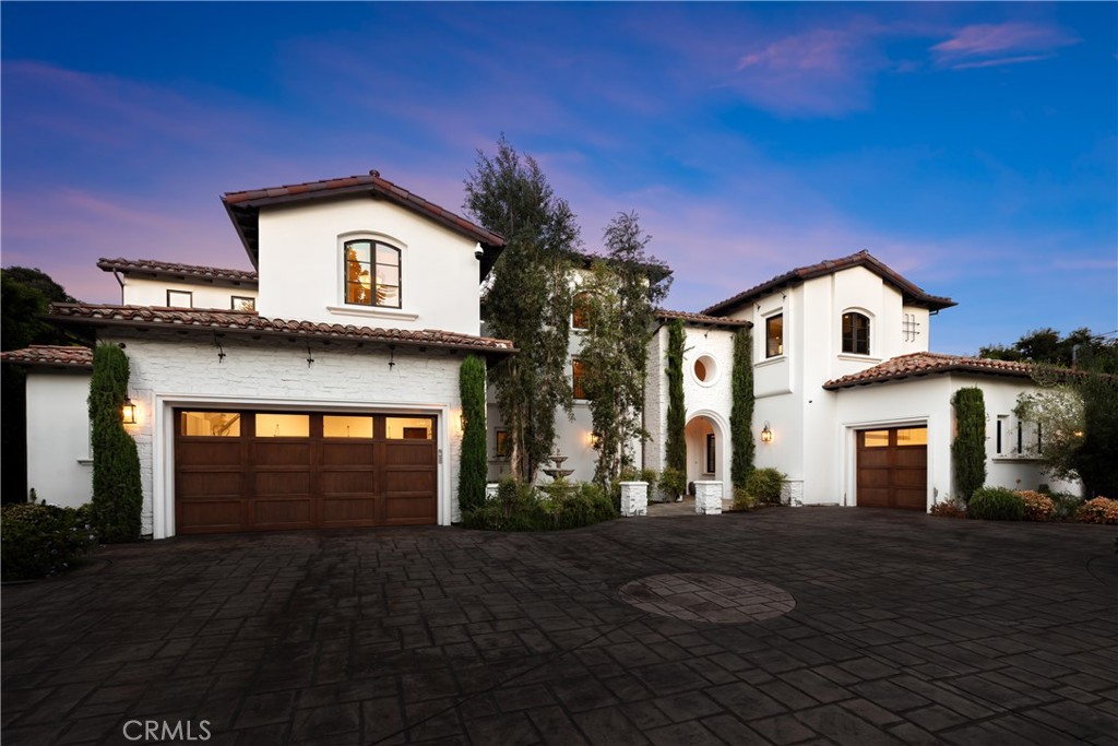 Situated in the prestigious Amestoy Estates of Encino, you’ll find this meticulously maintained Tuscan home. Feel and see the exquisite craftsmanship as you enter through double doors into a spacious open concept floor plan. The living room boasts a wood beamed vaulted ceiling, gorgeous fireplace and three sets of french doors that open up to the back patio. Moving into the formal dining room there’s an accordion glass door that opens to reveal one of two side courtyards, the perfect spot to enjoy al fresco dining next to a cozy outdoor fireplace. The gourmet chef’s kitchen features a breakfast nook, massive center island, walk-in pantry and top of the line appliances, including two wine fridges, two dishwashers and two double ovens. Open to the kitchen is the family room, complete with another accordion glass door that opens to the pool deck patio. Rounding out the main level is a home theater with surround sound, office, laundry room, temperature controlled wine cellar and ensuite bedroom. Upstairs you’ll find a luxurious primary suite that features a sitting nook, private balcony, dual closets and a sumptuous bathroom with a large steam shower, dual vanities and oversized soaking tub. Additionally there are three ensuite bedrooms with walk in closets, two of which have private balconies. Surrounded by mature privacy hedges, the serene backyard retreat consists of a sparkling saltwater pool/spa, poolside cabana, summer kitchen and large grassy yard. Further amenities include a Control4 smart home system, high ceilings throughout, a central vacuum, security system, two attached garages and an expansive motor court with double gates.