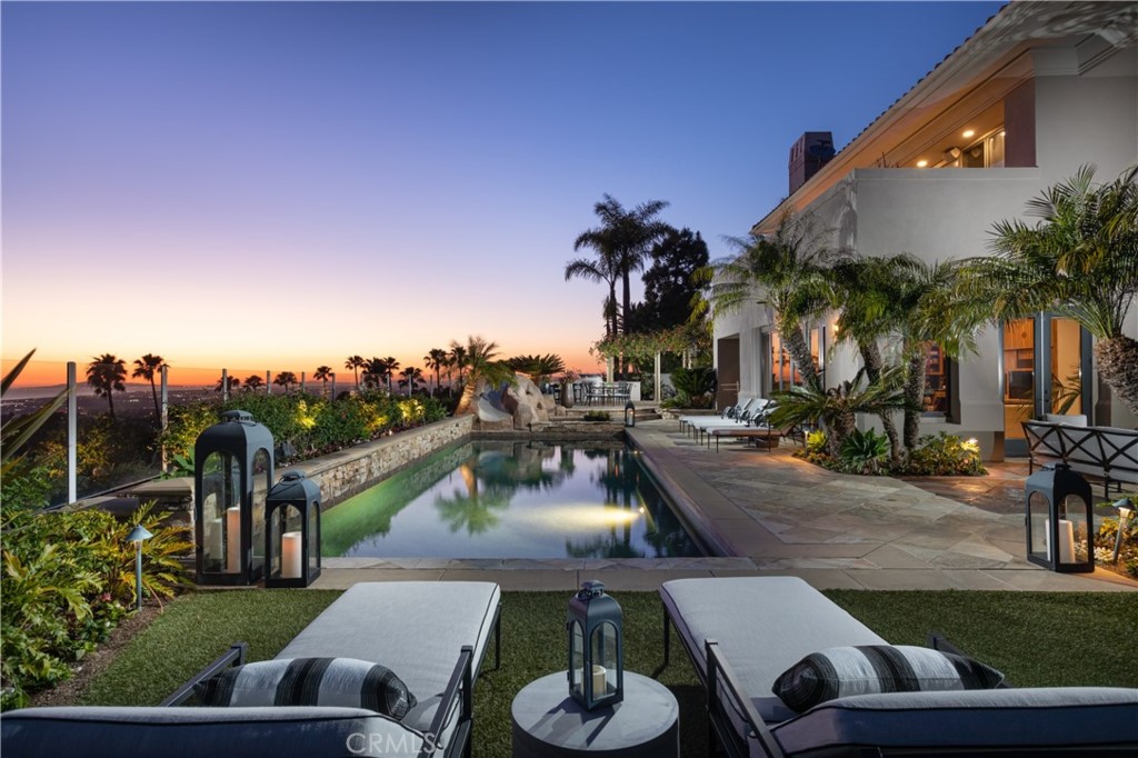 This attractive residence is perfectly situated at the most prominent and highest elevation in Pelican Ridge Estates with a generous 17,250 square foot cul-de-sac lot location providing the finest coastal views, overlooking Newport Harbor out to Catalina and an expansive 160-degree view of the blue Pacific. Gated courtyard entry with canyon stone pavers and fountain centerpiece welcomes you home. Lush landscape provides a sense of privacy and wellbeing. Formal entry, living room with fireplace, wood floors, piano alcove and French doors opening to garden courtyard. Formal dining room provides grand entertaining with a wine vault, wood flooring, coffered ceiling, decorator chandelier, crown molding and French doors open to shaded garden patio. Stylish with approximately 6,767 square feet a main floor ocean view suite, and additional guest or nanny bedroom, entertainment bar and powder room. Stone flooring adorns the casual room, kitchen, and hallways. True chef’s kitchen shows seamless granite counters, center island, decorator backsplash, stainless steel farmhouse sink, 2 dishwashers. Top name appliances include Viking stove top with hood, Subzero refrigerator, new Wolf double ovens and convenient by-the-glass wine dispenser. The split level provides a Bonus suite with kitchen area, Bonus room and additional flexible room for office or bedroom space, perfect as a long-term guest quarters or work from home environment. There is an envied fresh air fitness center in this residence that is sun and rain protected, fully ventilated and can be accessed from the Primary Retreat or Bonus Suite. The secondary bedrooms at top level provide a full suite, an ocean view suite and additional bedroom. The primary bedroom with full retreat possesses commanding Newport Harbor, Peninsula, ocean and Catalina views. Entertainer's yard has lanai for lounging and enjoying sunshine, formal entertaining area with fireplace, a casual conversation area with firepit and a beach area for volleyball, sand paddleball or beach-like lounging which is all complimented by a new pebble-tech finish pool and spa with water feature and water slide. Scenic outdoor cooking and serving area with ocean view counter seating or use the comfortable outdoor dining area with pergola. The garage can accommodate 4 cars and has plenty of closed cabinet storage area. HVAC system is three zone, two water heaters with circulating pumps, outdoor surfer shower and a deep driveway for convenient guest parking.