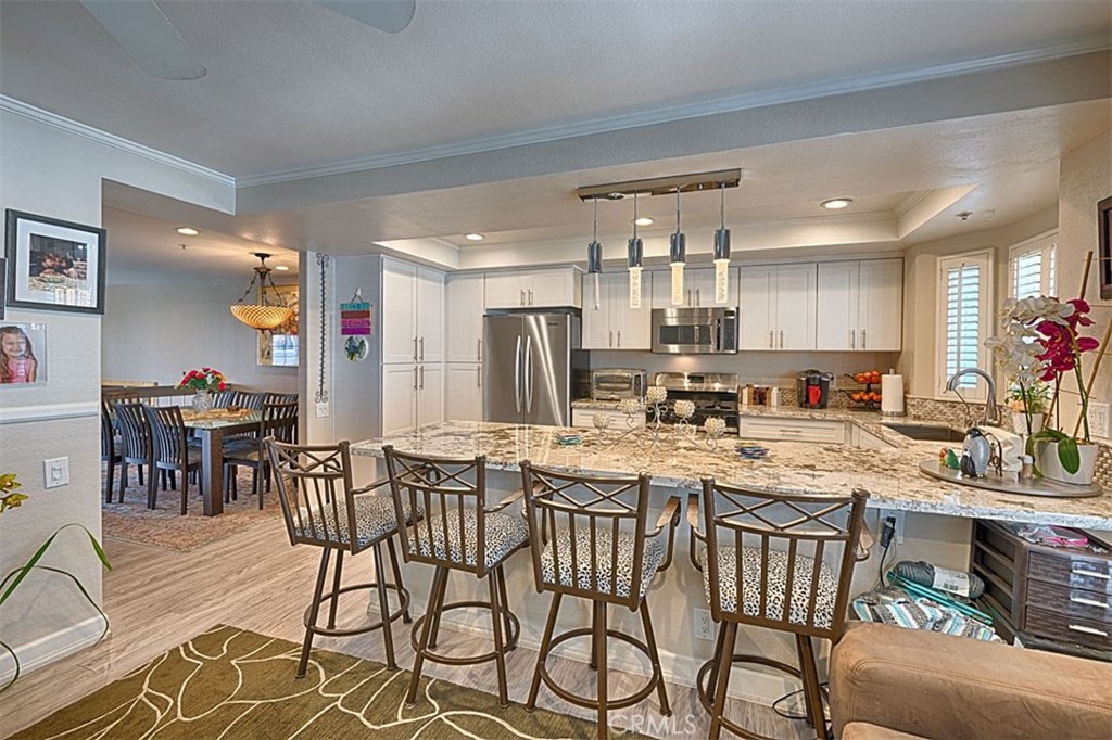 Welcome to beautiful Seawind Cove Community in Huntington Beach with lush landscaping throughout. As you enter the front gate, you are drawn into the patio area just awaiting your personal touch. Once inside, you notice the soaring, cathedral ceilings with canned lighting and open floor plan. You will be wowed by this remodeled unit, most notably wood laminate flooring, light and airy kitchen with soft-close cabinets/drawers, stainless steel appliances, spacious pantry, large breakfast bar, and impressive master bathroom boasting walk-in, rain shower, granite counters, ample storage, and decorative window/skylight adding to its airy appeal. All bedrooms and two bathrooms located on 3rd level, kitchen/dining and family room reside on 2nd level, and formal living room with adjoining garage access on main level. This turnkey unit is a must see! ... and don't forget Community amenities, including pool/spa, sauna and clubhouse.
