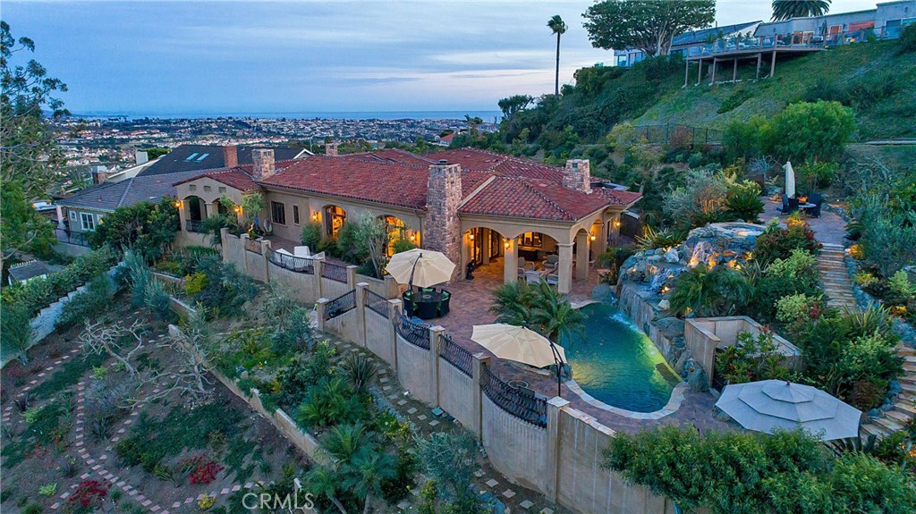 Three quarters of an acre, fully gated private estate just blocks to world class beaches. This custom built property was constructed in 2008 and rests upon a bluff top in Monarch Bay Terrace, near the Blue Pacific. Graced with soft ocean breezes the home exudes a peaceful tranquility. Enter the grounds and notice the privacy immediately while being embraced by a welcoming Mediterranean landscape theme enhanced with by outdoor lighting. A thoughtful single level 5BR 7BA design spans 5,650 Sqft and takes full advantage of its unique 34,090 Sqft lot. The buildable pad size is approximately 15,970 square feet. The remainder of the parcel maintains a very private environment with walking trails, orchard, multiple patios and an elevated spa patio with forever views. Quality craftsmanship and architectural mastery provide a Villa Resort feel, not unlike the great estates fancied in the finest European coastal areas. Interior appointments are boundless and include high ceilings, a fully wainscoted Theater Room, Great Room, library and wine cellar. All bedrooms are En-Suite style. The open floor plan creates an indoor/outdoor environment that showcases a Loggia with fireplace, outdoor kitchen and a pool with waterfall and beach entrance, all complimented by sweeping panoramic view. Additional private patio off the master. Less than a half mile to 2 golf courses and 2 tennis clubs with shopping and restaurants nearby. This collectors item parcel is an extraordinary opportunity.