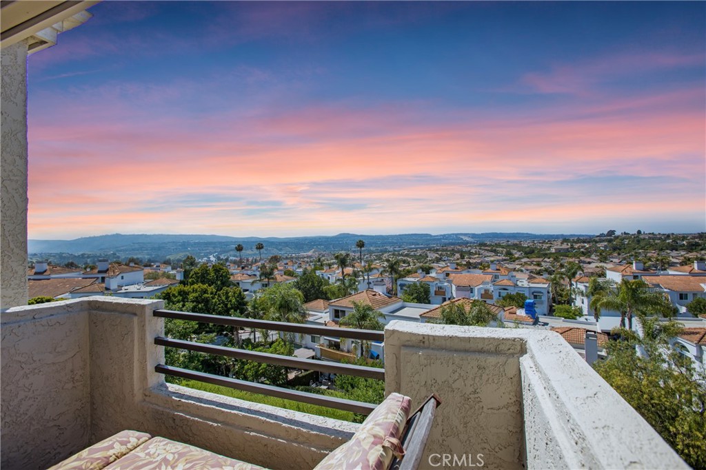 Welcome home to this two-story condo with spectacular views from the downstairs patio and upstairs balcony. These premium location properties are rarely for sale. Enjoy the incredible sunset views and fireworks display in the distance during the celebration of freedom. The interior boasts porcelain tile downstairs with ribbon inlays at the entry and around the fireplace and porcelain tile in the wet areas upstairs. Strand Woven Cherry Bamboo flooring in the hallway, staircase, and both bedrooms. The open kitchen concept has a bar counter with two newer swivel stools for viewing options, stainless steel appliances, and lots of pantry space. The dining area off the kitchen leads to a view patio. Cozy fireplace in the living room. A convenient ½ bathroom is located downstairs with an upgraded vessel sink and granite countertop. A full-size laundry room is between the kitchen and the direct-access garage with an extra quiet door opener and added shelving.
Upstairs, the primary bedroom has high vaulted ceilings, a walk-in closet, and a panoramic view balcony. The primary bathroom has new sink faucets and an updated dual vanity. Oval tub in the shower. Remodeled full bathroom in the upstairs hallway with ribbon inlay tiling, updated vanity with granite-style countertop. The secondary bedroom has mirrored wardrobe doors. This Expressions community was re-piped with Pex plumbing material. Low property taxes and association fees, which include water and trash.
Relax at this spectacular resort-style community pool and spa, which features a shower, bathroom amenities, and tables under a covered patio. Excellent dining, 4 plaza shopping, and theatres are just a walking distance away. Easy access to the toll road, 5 freeway, and Costco. Great schools and parks, beaches, and walking trails are nearby.