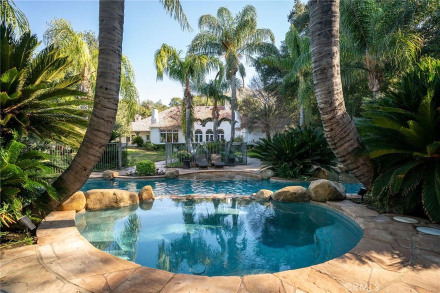 THE MANOR ON JOSEL has an old-world charm, sophistication, and romance - yet feels brand new and incredibly inviting. This single-story 4,414 square foot home has 4 bedrooms, 5 bathrooms, plus an office and studio, and an unfinished attic that was originally designed to include a staircase with 3 additional bedrooms and 2 more bathrooms. That space could EASILY be converted into whatever your heart desires, giving you incredible added square footage! Nearly every one of the huge living spaces opens up to the outdoors, taking advantage of the views of the lush landscaping that feels like a tropical vacationland. The 2.28 acre property is privately gated, and has its own well that produces free water to keep the grounds so luscious it doesn't even look real! The gorgeous lagoon-like pool, spa, grotto, and slide are like a resort with hand-picked palm trees framing each space. The massive outdoor pavilion holds the fully-owned solar system on the roof and includes an outdoor kitchen, living area with fireplace and TV, heaters, and enough space in and around it to host large events. If that wasn't enough, you also have a 40’x40’ detached workshop/garage out of sight on the back of the property, an INCREDIBLE garden structure, TONS of fruit trees, and plenty of space for horse facilities, RV storage, etc. This home is unlike any other!