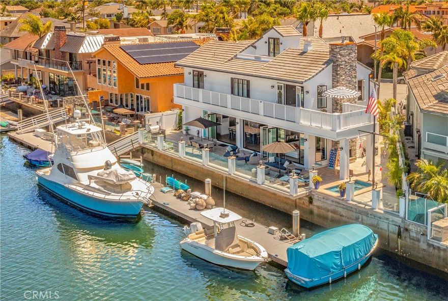 Arguably the most impressive waterfront home for sale in Huntington Harbour.  Rarely available premium lot with 97 feet on water, 86 foot side-tie boat dock + end tie for Duffy.  Luxury Quality Coastal Contemporary architecture completed in 2019… absolutely gorgeous with a “lite & brite” vibe which must be experienced to be appreciated.  Quiet cul-de-sac location and leeward patio make this one of the most relaxing and quiet locations of its kind in the area, yet it is just a short stroll or bike ride to Harbour View Elementary School, restaurants & shopping at the Harbour Mall.  It is a nice bike ride down Warner Avenue to Bolsa Chica Beach.  Features include: 4 Bedrooms + Study + Office, 4.5 Baths (yes there is a bedroom & full bath downstairs). Upstairs laundry room + stacked Washer & Dryer in the oversize garage which features two single doors plus door for bicycles/motorcyle. Large waterfront patio with: Outdoor BBQ area, resort swings, nautical flag pole, fireplace, spa, dining, & lounge areas. Bonus Feature: Ultra private 3rd floor sundeck with views of the harbour, mountains, and sunset! This is the ideal property for the Yachtsman who appreciates wide water views and a home designed to entertain both large & small groups of guests: Plenty of room on the dock for multiple yachts, Duffy, skiffs, kayaks, sabots, & paddle boards. Very large yachts can be singlehandedly docked on the windiest of days thanks to the minimal current & leeward location. Paddleboarders & Kayakers appreciate the uncrowded calm waters of this area of the harbour, and when it is time to take the big boat for a cruise, it is just 23 miles Catalina Island. The Queen Mary, Los Alamitos Bay, & Shoreline Village are additional nearby over-the-water cruising destinations for an enjoyable day on the water! Be sure to look at the photos, floorplan, and walk-thru 3D tour, then book an appointment to see this unique “move-in ready” home!