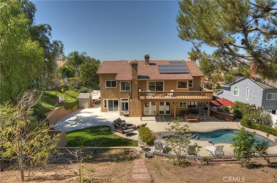 Don't miss this drop dead gorgeous home that has it all! 5 bedrooms, 4 baths 3729 sqft & almost half acre lot size! Enter into the foyer with a wrought iron staircase, travertine flooring, high cathedral ceilings an impressive formal dining room w/exquisite fixtures. Step down into a dramatic formal living room, with rich hardwood throughout the first floor. Natural lights stream though custom windows. The upgraded kitchen features French cabinetry and an endless granite bar w/artistic moldings, a built-in bar, fireplace, stainless steel appliances & sub zero refrigerator. A large breakfast nook overlooks the lush grounds. A downstairs bedroom and full bath is perfect for guest. A secondary staircase leads to the upstairs landing. The master suite has a separate retreat area w/fireplace & large deck with views of the private backyard. A master bath features travertine inlays, an oversized soaking tub, travertine shower & dual sinks. Generous master walk-in with built-ins. 4 bedrooms with loft area are located upstairs. Plan on entertaining in this amazing back yard with all the amenities of a luxury resort surrounded by serene landscaping, private saltwater pool, spa, waterfall, fire pit, built in BBQ , Island with custom decking & a sport court. You could host a gathering for more than a 100 people with room to spare. 3 car garage w/epoxy, RV access, hookups, drains, energy efficient solar panels and a cul-de-sac location complete this home. Travis Ranch, Yorba Linda High