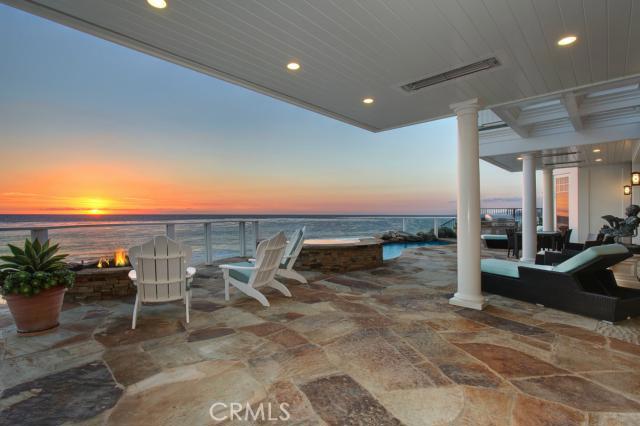 Elegantly relaxed, this Cape Cod-inspired home rests on the white sand of Strand Beach and retains over 9,950 sf of oceanfront luxury. Architect Chris Light’s design beautifully captures the sights and sounds of the ocean with picture windows and custom retractable walls of glass opening to terraces, decks, infinity pool and spa, and the ocean beyond. Fine finishes include Dutch door entry, wood floors in parquet pattern, custom woodwork and built-ins, rare stone surfaces, custom lighting and designer window treatments The main level includes a gourmet kitchen, breakfast room, family room, great room, guest suite and office. The upper level has four bedrooms including an expansive master suite with terrace and sitting area, plus artist’s studio, library, and laundry. Lower level opens to gentle Pacific breezes and provides a game lounge and bar, stadium-style theater, fitness center with spa bath and steam shower, massage and exercise rooms. The Strand at Headlands is a 24-hour guard gated community with a private clubhouse and is minutes from Dana Point Harbor, Monarch Links Golf Club, and Ritz-Carlton and St. Regis Resorts.