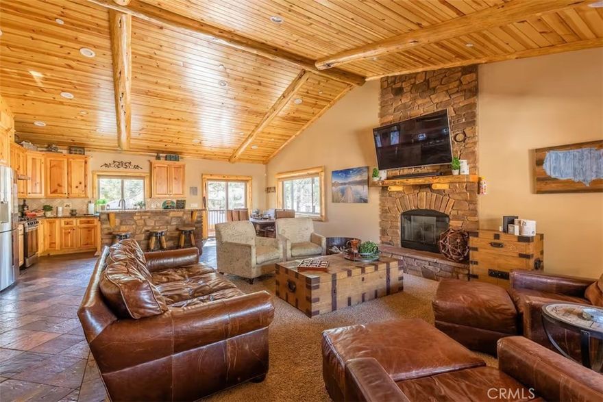 Stunning 1,700 Sq. Ft. Single-Story Home in Eagle Point – Optionally Fully Furnished with Established Book of Business! Welcome to this beautiful single-story home in the highly sought-after Eagle Point neighborhood of Big Bear Lake! This 3-bedroom, 2-bathroom retreat offers 1,700 sq. ft. of thoughtfully designed living space, blending modern upgrades with cozy mountain charm. Step inside to a bright and airy open-concept living area, featuring vaulted wood-beamed ceilings, a floor-to-ceiling stone fireplace, and expansive windows that bring in plenty of natural light. The gourmet kitchen is a chef’s dream, complete with granite countertops, modern appliances, and a spacious walk-in pantry—perfect for entertaining after a day on the lake or slopes. The primary suite offers a private retreat with ensuite bath access, while the additional bedrooms provide ample space for family and guests. A dedicated laundry room adds convenience, and the home also features an extra-long and wide two-car garage, ideal for storing vehicles, gear, and outdoor equipment. Additionally, the home is equipped with a whole-house fan, providing efficient cooling and improved air circulation. Step outside to enjoy the expansive wraparound deck, where you can sip your morning coffee, stargaze at night, or host barbecues in the crisp mountain air. This property comes fully equipped with an established book of business, making it a fantastic short-term rental investment with proven revenue potential. For added convenience, the home is optionally available fully furnished, allowing for an easy transition into a personal getaway or a turnkey rental opportunity. Located just minutes from Snow Summit, Bear Mountain, Big Bear Lake, and shopping/dining in the Village, this home is a rare opportunity to own an upgraded mountain retreat with income potential! Don’t miss out—schedule your private showing today!