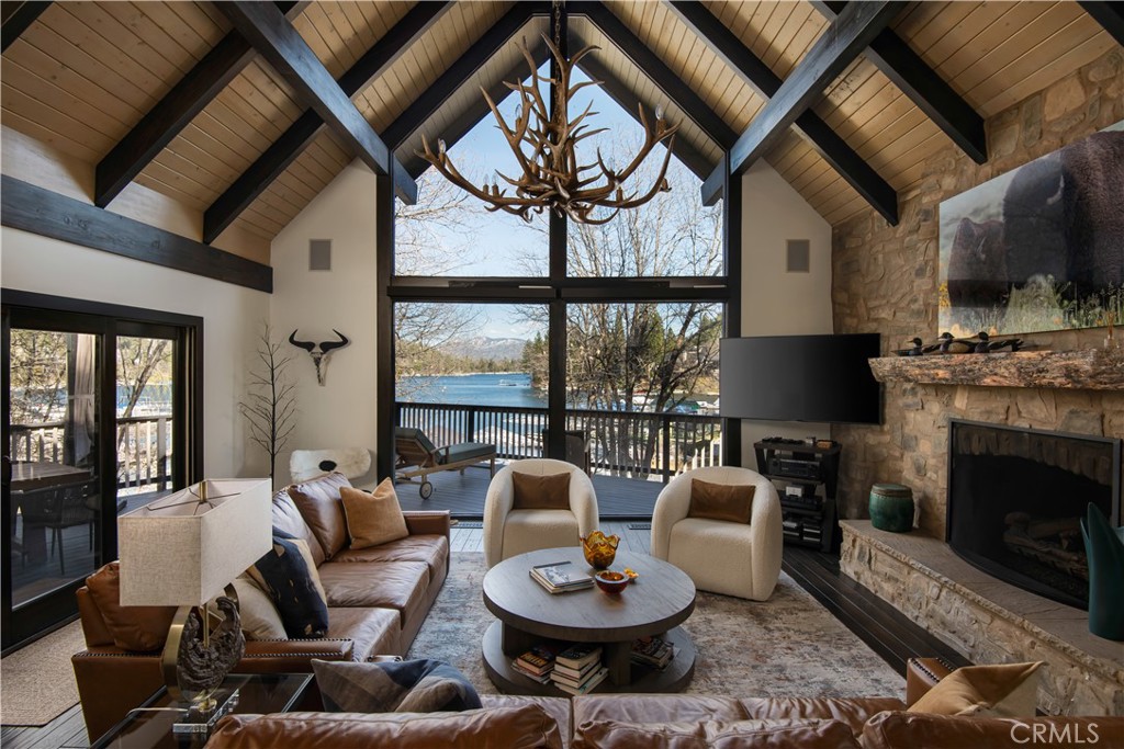 Timeless Lakefront Estate in Coveted North Bay Location.
Privately nestled in the serene waters of North Bay, this timeless lakefront estate embodies the ideal mountain retreat every buyer dreams of. Set back discreetly from Lake Trail and the street, the property offers unmatched privacy, accessed via a long driveway leading to a spacious carport accommodating 8+ vehicles.
Upon entering through the level entryway, you're immediately welcomed by soaring vaulted ceilings and a grand stone fireplace, setting an atmosphere of warmth and elegance. Oversized windows frame breathtaking panoramic views of Lake Arrowhead and lush forest landscapes, bringing nature seamlessly indoors.
The interior is adorned with exquisite hardwood and Italian tile flooring that flows effortlessly through the home. The kitchen has been tastefully renovated with premium appliances, stunning white quartz countertops, a chic designer backsplash, and ample dining space—perfect for hosting memorable family gatherings. Additionally, there is a large walk-in laundry room combined with an oversized pantry area for abundant storage of overflow groceries and supplies.
The home features five spacious and oversized bedroom suites, each boasting generous walk-in closets and private bathrooms, with one conveniently situated on the main level. Three of the suites include their own private decks, while four offer spectacular lake views. A versatile loft area provides the perfect space for an office or study, with inspiring crystal-clear vistas of the water.
Entertainment options abound with a vibrant lower-level game room featuring a pool table, shuffleboard, and thoughtfully designed spaces for endless enjoyment. Step outside to two impressive outdoor areas: a wrap-around main deck with multiple dining and lounging zones, and an expansive lower-level patio complete with a cozy fire pit, seating areas, and a foosball table.
A short stroll from the home leads you to your private single-slip dock, uniquely equipped with electricity, a newly added protective roof, and an oversized grandfathered platform ideal for lakeside relaxation. Additional upgrades include newly installed air conditioning units, a whole-house generator, designer lighting fixtures, fresh paint, and sophisticated designer furnishings throughout.
Furnishings and boat are available separately, providing a turnkey opportunity to begin enjoying lakeside luxury immediately.