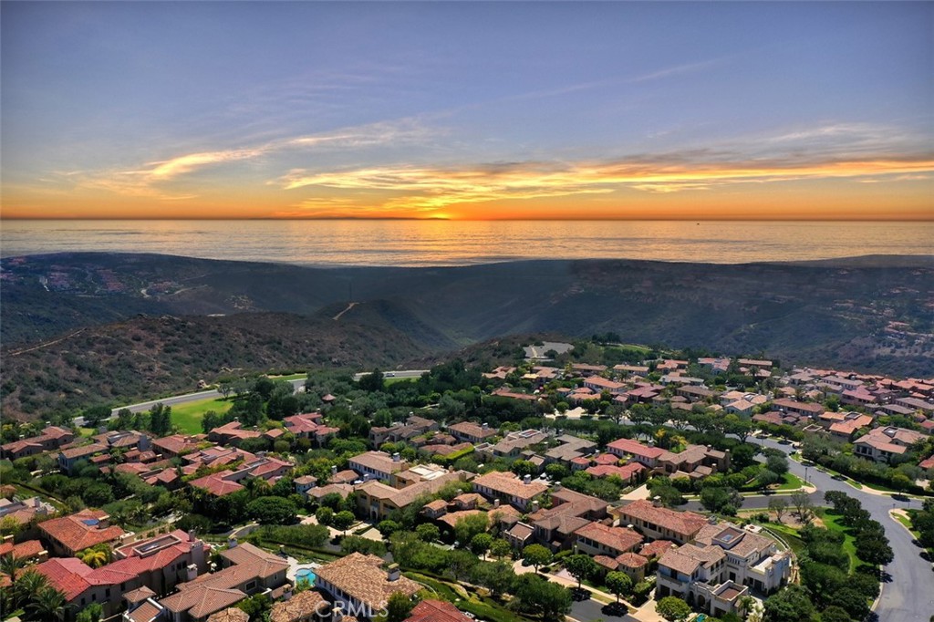Perched high on the hillside in the 24 hour guard gated community of Newport Coast, discover this palatial estate, “The Jewel of Ocean Heights.” This property boasts 6344 SF of living space with 3 separate wings, all with an expansive private suites. The pièce de résistance is the sumptuous main bedroom upstairs, featuring nearly 2000 SF. Enjoy sweeping ocean views from the balcony, bedroom and “Belaggio” style bathroom; a space where endless water views abound and you can soak and relax while gazing at the majestic Pacific. The home is remarkable, with unique features, thoughtfully designed to accommodate large or multi-generational families. The immense size allows for myriad of opportunities to convert the current floorplan to a six bedroom house, and the garage space from 3 to 4 car if desired. The “portico” is an ideal spot for a private art studio. This home has every desired amenity and is situated on a 12,000 SF ocean view lot with panoramic vistas reaching from Palos Verdes to Dana Point with Catalina off in the horizon. The backyard resort with private pool and spa is the ideal escape and the perfect space to savor the indoor/outdoor lifestyle Southern California. Prepare gourmet meals in the chef’s kitchen and dine al fresco while enjoying those spectacular views. Hiking and biking trails, world class beaches, shopping and dining are minutes from this premium hillside location. Amenities include multiple security cameras, temp controlled wine room and an elevator.