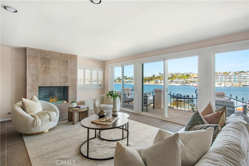 Charming Lido Isle Bayfront with Direct Beach Access & Spectacular Views. Perfectly positioned on the Lido Isle bayfront with its own stretch of sandy beach, this charming home offers an idyllic coastal lifestyle in one of Newport Beach’s most coveted island communities. Lovingly maintained and thoughtfully upgraded, the residence blends timeless design with modern comfort—creating a serene retreat just moments from all the island’s amenities and the excitement of Lido Marina Village. Spanning approximately 2,900 square feet, the home captures breathtaking harbor views from nearly every room. Wake up to sailboats gliding by, rowers cutting across glassy morning water, and unforgettable sunrises—all visible through the wall-to-wall windows of the primary suite or enjoying your favorite beverage on the bayside patio. The layout features a desirable first-floor bedroom and bath, ideal for guests or flexible living, an open-concept kitchen, living, and dining area designed for easy entertaining and daily enjoyment of the water views and everchanging scenery on the bay. Recent updates to the kitchen add functionality and warmth, while expansive glass doors connect the indoor spaces to a bayside patio where you can lounge, dine, or dip your toes in the sand. Upstairs, a rear deck provides another private outdoor escape. The home’s orientation and location offer the rare combination of up-close bayfront living with the comfort of a walkable beach right outside your door. Enjoy exclusive access to Lido Isle’s private beaches, clubhouse, tennis courts, parks and a true sense of community. Just a short stroll away, discover the vibrant shops and restaurants of Lido Marina Village, adding a dash of cosmopolitan flair to this relaxed waterfront lifestyle.
Whether you're watching the weekly sailing races, enjoying the rhythm of the harbor, or simply soaking in the sun, this home offers an extraordinary opportunity to experience the best of bayfront living on Lido Isle.