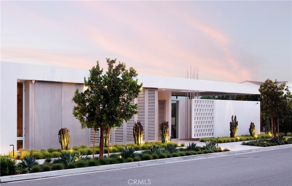 Rooted in Classic Modernism and presenting a narrative of open & porous space celebrating light, air, and water. This residence will be the first in Orange County to actualize the Darwin™ Premier Wellness Ecosystem for residences, by Delos™. Designed to enhance energy, sleep, and well-being, while reducing harmful indoor contaminants; bringing together a sensor monitoring platform across air filtration, water purification, circadian lighting, and comfort features. Experience a private courtyard with a grand two-story living wall adjoining the meticulously finished guest casita/office. Delicately balancing sophistication and function, the living areas unfold to the fluid textures of the infinity pool and the Pacific Ocean. Embrace Catalina Island in the distance from the private master suite warmed with a limestone and walnut fireplace. Just beyond the artfully crafted, juxtaposed bookcase are two additional bedroom suites. Descending a circular helix staircase, the lower level reveals an amorous lounge with wine wall & billiard table, aligning the intuitive programming of the media space with the natural elements. Indulge in the amenities of the wellness spa, befitting a resort experience, unfolding to a 900 square foot open-air terrace with reflecting pool and lush two-story living wall.