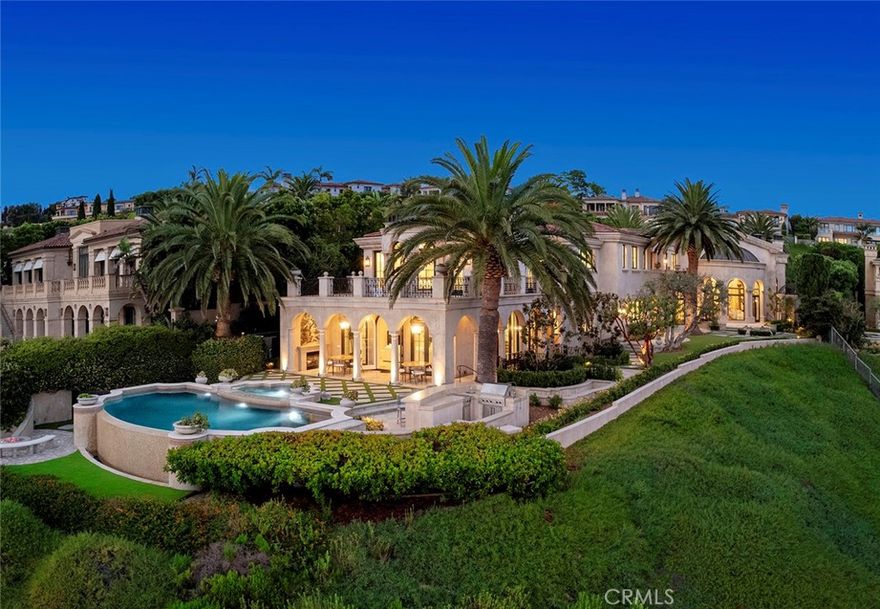 Situated on a prized front-row lot, this Pelican Crest showpiece estate was newly refreshed in late 2023 and enjoys unobstructed views of the Pacific Ocean, Catalina Island, Newport Harbor, Pelican Hill Golf Course, spectacular sunsets, and twinkling evening lights. Bespoke transitional interiors of approximately 14,000 square feet provide unsurpassed comfort and hosts seven bedrooms and twelve baths. Authentically detailed architecture, romantic archways, columns, domes, and Palladian windows work in tandem to create first impressions that will last a lifetime. A phenomenal entry with custom glass and iron door sets the scene and introduces airy galleries, a library, formal living room, and lavish guest suite complete with a private sitting room. Awaiting at the heart of the home is a two-story oval foyer which reveals a dramatic staircase, formal dining room for both grand-scale and intimate entertaining, and a spacious great room with six sets of French doors that open onto a fireplace-warmed loggia. Grandeur is elevated to lofty new heights with custom lighting, multiple interior and exterior staircases, impressive fireplaces, and one-of-a-kind flooring. Catering to professional and amateur chef’s alike, the gourmet-inspired kitchen complements timeless style with a butler’s pantry, center island, and a breakfast area. From romantic evenings at home and impromptu gatherings to formal affairs that are destined for the social pages, the generous floorplan offers three service bars and accommodates every occasion with style and sophistication. An elevator serves all four levels, including a basement with an eight-car garage, game room, gym, sauna, and steam shower. Take the stairs or elevator down to the sub-basement where a 34' indoor swimming pool is destined to be a favorite place for all who visit. Captivating ocean vistas embellish the owner's suite, where a large view terrace, sitting area, fireplace, dual walk-in closets, separate vanities, and a glamorous soaking tub fulfill the residence's promise of delivering uncompromising luxury. Lushly landscaped grounds recall the beauty of an exclusive Mediterranean resort, where graceful palms, broad lawns, and sunny patios are joined by a sublime ocean-view swimming pool and spa. Set just moments from championship golf courses, five-star resorts, high-end retail, and upscale dining, 14 Channel Vista represents a truly rare offering.