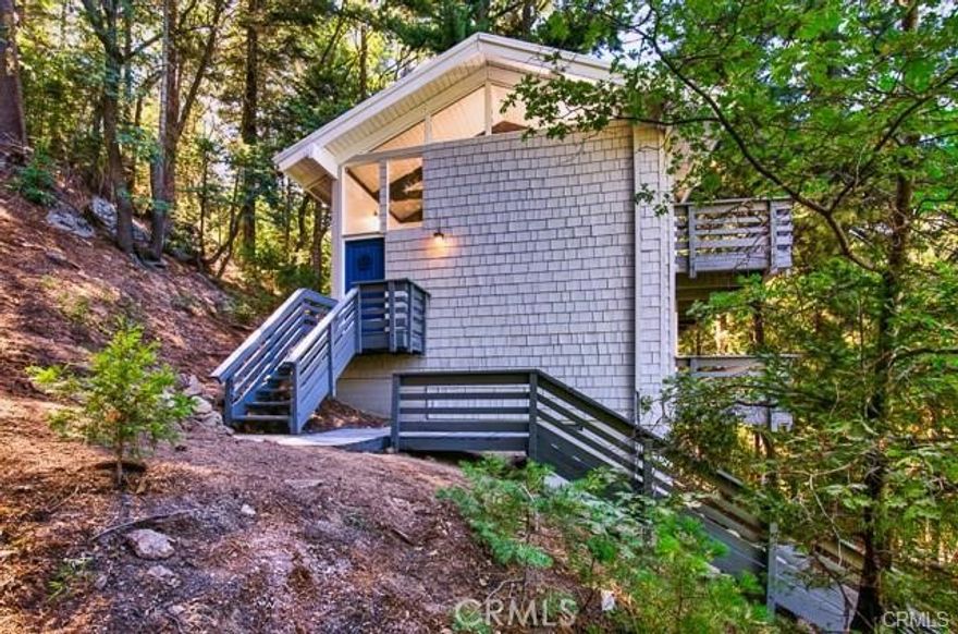 Welcome to HavenHaus – where SECLUSION meets tranquility. Tucked away at the end of a private access road, with NO NEIGHBORS except the forest inhabitants, this remarkable retreat offers an unparalleled sense of PRIVACY, a place to unplug and exhale, a hidden gem nestled in nature's embrace.

Step into your own sanctuary, as you enter, you'll be greeted by a split staircase. Go down to the 2 bedrooms or up to the open floor plan that seamlessly blends indoor and outdoor living, creating an enchanting ambiance reminiscent of a modern-day treehouse.

Gather around the wood-burning fireplace in the spacious living area, where open beams  highlight the vaulted ceilings adding a touch of rustic charm. Dual decks invite you to soak in the surrounding natural beauty, offering the perfect spot to unwind and connect with nature.

The heart of the home boasts espresso shaker cabinets, granite countertops, and stainless steel appliances. Laminate flooring throughout ensures easy maintenance and a cohesive flow, while large windows frame picturesque views of the lush landscape.

Rest easy in the two downstairs bedrooms, each featuring three-panel closets for ample storage. The utility room conveniently houses the water heater, furnace, and stackable washer/dryer, making household chores a breeze.

Outside, discover your own slice of paradise, where peace and quiet reign supreme. Immerse yourself in the sights and sounds of nature, with squirrels, chipmunks, and stellar jays as your neighbors, and the occasional deer making a graceful appearance.

And as a special treat, over 1,300 tulips and daffodils await to greet you with vibrant colors and sweet fragrances, adding an extra touch of charm to this already enchanting haven.