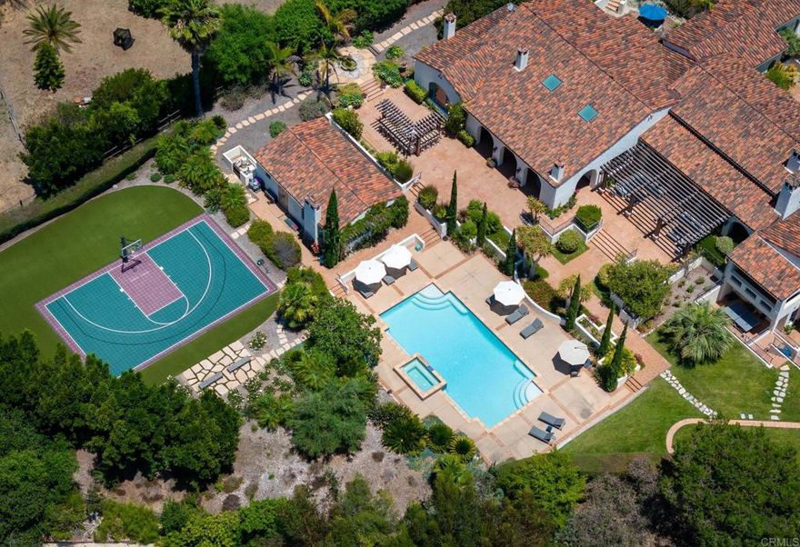 In the true spirit of Rancho Santa Fe, a heritage defined by its timeless ambitions of the West, early California Spanish Revival Hacienda--perched on a cul-de-sac--spans an estimated 10,000 square feet of luxury living and entertaining; customized by local talents, the entire estate encompasses 1.77 acres on a private and quiet Covenant location with Westerly views. The authenticity and historical respect infused within the home's fresco design is ever apparent in the detail of expressed arches, intimate outdoor courtyards and plazas and artisan-crafted custom materials; reclaimed distressed and oiled oak and chestnut flooring, leathered Saltillo and hand painted tiles from Mexico, hand carved stone fireplaces, custom wrought iron railings, groin vaulted ceilings with herringbone brick detailing, wrought iron fixtures and gates, and a striking display of exposed heavy timbers that have been carefully carved, oiled and perfectly placed. Accolades of the residence offer: 5 suites of bedrooms including the primary with fireplace, coffee bar, separate custom appointed dressing rooms and a covered outdoor veranda overlooking the back yard.  In addition there is an office with stunning hand designed and carved cabinetry, state of the art home theatre, billiards/game/music room/man cave, wine cellar with temperature controlled storage and display shelves, gourmet kitchen with coffee bar opening to the great room with entertaining bar for indoor/outdoor service, dining room with fireplace opening to a private courtyard, inviting formal living room with decorative fireplace, pool and spa terrace, fire-side lounging/dining loggia, outdoor stone flanked summer kitchen, separate one bedroom/one bath guest casita with living room and service bar, pool bath, outdoor shower, sport court, house solar, garage parking for 4.  The grounds are magnificent with beautiful specimen foliage throughout. All gated and fenced. The perfect location within the RSF Covenant.  Roger Rowe Schools.