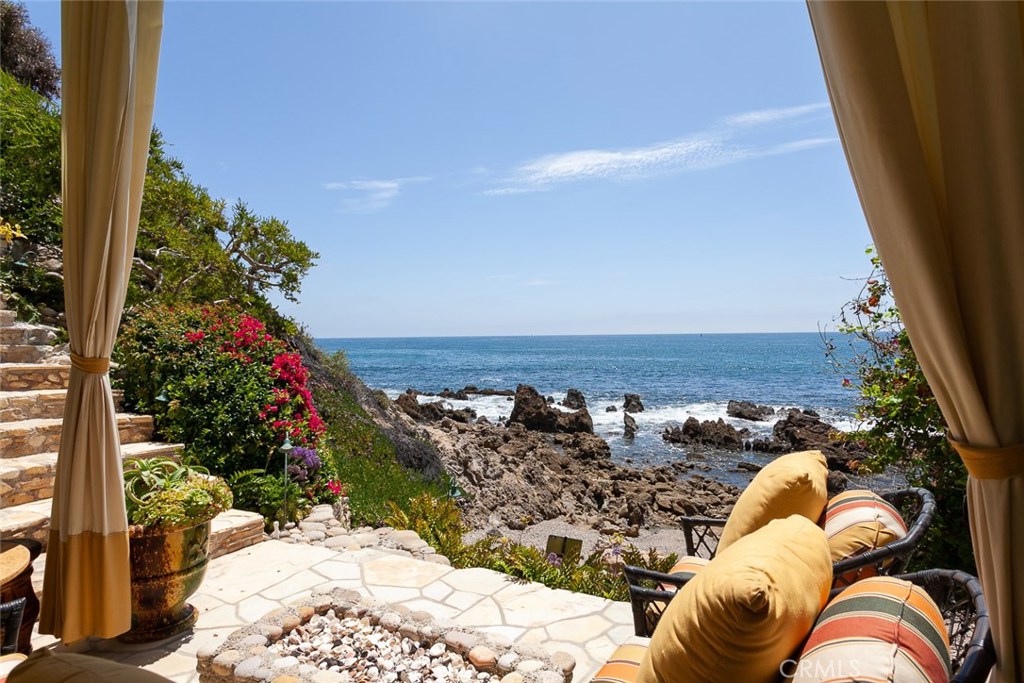 Just off of Inspiration Point in Corona del Mar and completely invisible from the street stands an extraordinary bluff-top home with unparalleled ocean views and five stories of elegant seaside living. Privacy and elegance convene in this Brion Jeannette-designed homestead, where a hidden drive leads to a lush motor court behind gates, the only privately gated residence in the area. A magnificent spiral staircase spans all five floors and leads to the top level of the home, featuring private guest quarters in a charming setting. The gourmet kitchen features an expansive island, Viking and Sub-Zero appliances and granite countertops and leads to a convenient Butler’s pantry. Follow the elegant staircase to the second floor you’ll find three bedrooms – two beautifully appointed guest rooms and the uncompromising Master suite. The first floor of this masterpiece is an entertainer’s dream. A massive family room with floor-to-ceiling windows and additional guest quarters with a separate office completes this floor, as well as a jacuzzi tub on the limestone balcony. Steps down lead to an exclusive cabana, complete with fire pit. Further steps escort you to your own private beach with water access, the only home in the cove to boast this amenity. Equipped with a five-stop elevator and Smart home technology, it’s quite simple to navigate the home’s levels and amenities. Located in the heart of Corona del Mar means that schools, shops and restaurants are a stone’s throw away.
