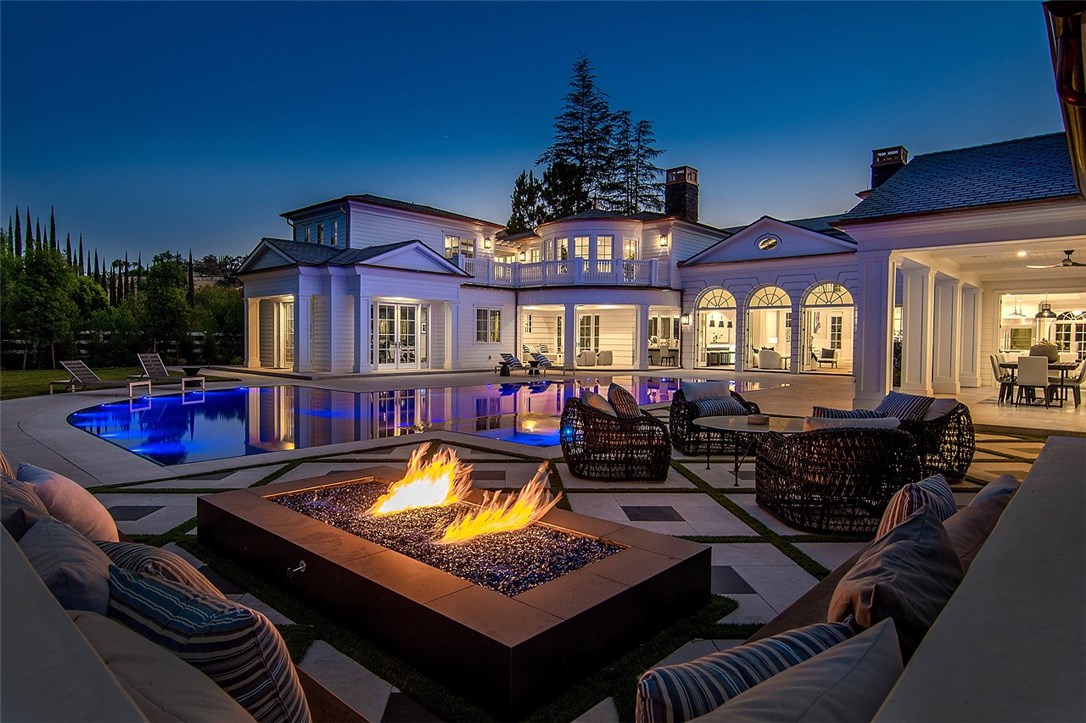 Completed in 2017, this gorgeous custom estate is light, bright and beautifully finished throughout! Step through the entry doors into a world of true quality and elegance. Highlights include a stellar gourmet kitchen that opens to the spacious family room, plus an adjoining game room with wet bar, superb movie theater, custom paneled office, and a beautiful, sun drenched two-story gym complete with massage room. The sumptuous master suite offers an all-stone bath, steam shower and expansive, dual custom closets. Additional amenities include an elevator, sauna, refrigerated wine cellar, programmable lighting system, security system complete with cameras, outdoor living room with fireplace, indoor/outdoor bar, pizza oven, BBQ center, and fire pit. There is also a full guest house with a second kitchen, and it's own private driveway, plus an additional 7-car garage (the square footage shown includes the main house & guest house). The lushly landscaped grounds include a sparkling zero edge pool with Baja Entry and color-changing LED lights, plus large spa, circular driveway with entry fountains, and a wine producing vineyard. The quality sound system lets you enjoy your music selections, and if you want to create your own music, step into the newly-completed, ultra-modern recording studio. Featuring a wonderful open floor plan, high quality finishes, and numerous amenities, this one-of-a-kind estate truly has much to offer a discriminating buyer. SEE VIDEO TOUR IN MLS LINK.