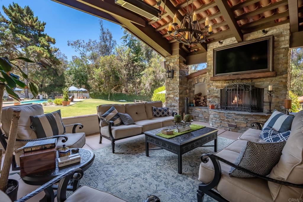 Located in the exclusive Covenant of Rancho Santa Fe on the West side, this gated, walled and fenced estate sits on 3.01 of parklike, colorful and mature landscaped acres with garaging for 13 vehicles for the car enthusiast and an arena, horse corrals, tack and feed room and a private bridle path circling the property for the equestrian lover. Encompassing 5,241 square feet of early California architecture with soothing interiors and walls of glass that open to the outdoors, creating an indoor/outdoor living and entertaining/lounging experience. There are 5 bedrooms suites and 2 offices/libraries. The large formal living room with wall of glass slides open to the exterior with views to the beautiful private park like backyard….. the perfect venue for large gatherings and entertaining. The chef’s kitchen with top of the line appliances, formal/ informal dining area and serving bar opens to the family room with fireplace, entertainment center, and wall of glass that opens to the exterior living/dining room with fireplace, entertaining bar and full summer kitchen overlooking the sun splashed pool. There is a game/bonus room that connects to a 2 bedroom/2 bath guest house with full kitchen (these 2 bedrooms are counted in the total 5 bedroom count). For outdoor entertainment there is the oversized pool for swimming laps or for play, lots of areas to explore, horse facilities and garaging for 13 cars. The property is adjacent to the Covenant’s trail system. Sewer. Natural Gas. Firepit. The Rancho Santa Fe Covenant community is beautiful with a highly acclaimed school system (Roger Rowe) and the privilege to join the legendary Rancho Santa Fe golf and tennis clubs. Great location with easy access to the Covenant Village, shopping centers and all major freeways.