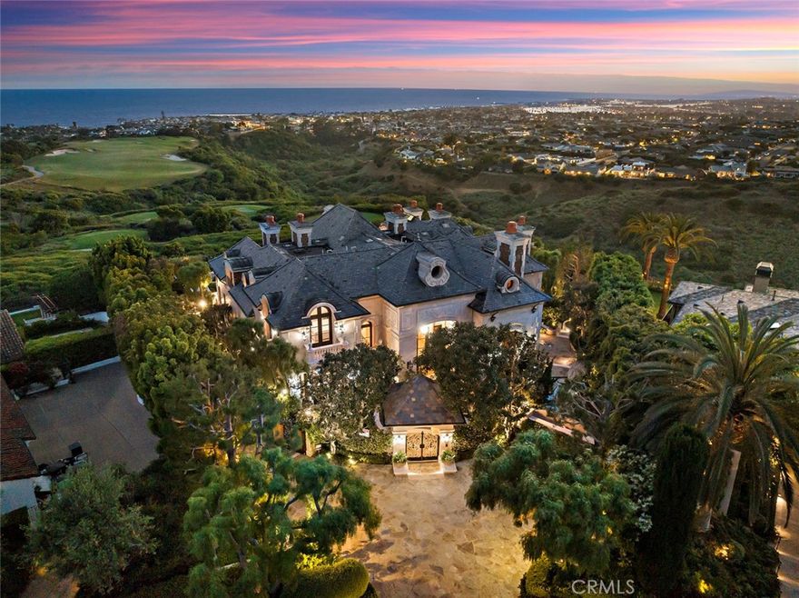 1 Premiere Point is an address unsurpassed in its prestige, evoking a sense of sublime luxury and offering a rare opportunity to own a nearly ¾-acre parcel on Newport Coast’s coveted front row. Perched on the edge of the Pelican Hill Resort with 240’ feet of view frontage, this prime locale offers commanding views of the iconic coastline, giving the feeling that all of Southern California is within your grasp; from the sunsets over Palos Verdes melding into the Pacific, to Catalina and San Clemente Islands looming large, while the ultra-luxe yachts of Newport Harbor beckon, city lights glisten, and Pelican Hill Golf Course lies at your feet. Sun-drenched limestone walls and a slate roof give way to a recently refreshed interior that offers 11,402 s.f. +/-, with 6 bedrooms, 9 bathrooms, and an elevator for effortless access. A lavish foyer links to a living room with intricate moldings, a stone fireplace, and a row of ocean-facing French doors. An open family room is a comforting space to host friends and family, featuring a wet bar, fireplace, and French doors that open to an airy loggia. The adjoining kitchen is equipped with top of line appliances, a prep sink, and an oversized island. The demands of an extraordinary lifestyle are anticipated and effortlessly met, with a 2-story library, dedicated theater with a new state-of-the-art projector, large wine cellar, full home gym, and a 8-car garage. The primary bedroom is a calming retreat, with a fireplace, sitting area, couture-worthy dual closets, and French doors that open to a balcony overlooking manicured greens and rugged coastline. Dual ensuite bathrooms radiate luxury, with opulent stone surfaces, and every amenity necessary to indulge in pure bliss. Five secondary bedrooms offer ensuite bathrooms for an elevated guest experience. Situated on a quiet cul-de-sac, sprawling private grounds offer an immersive experience in enchanting French charm, featuring covered loggias, a barbecue pavilion, infinity pool, spa, formal gardens, a terraced lower yard with a verdant lawn, and koi pond with cascading waterfall. Whether hosting spirited cocktail parties or intimate gatherings, this is where memories of the sun dipping below the ocean linger long after the last ray fades. Residents are nearby to the prestigious Pelican Hill Resort and Golf Club, Fashion Island, world-class dining, and the beautiful beaches of Newport and Laguna.