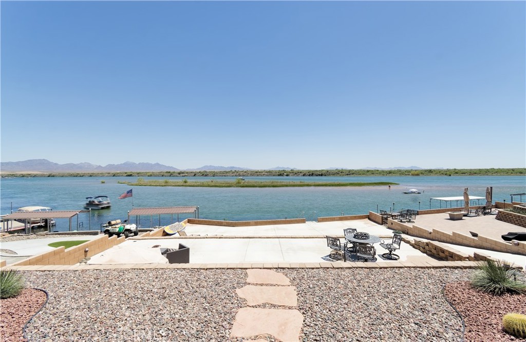 HUGE PRICE IMPROVEMENT! Summer is coming so make sure and check out the coolest house on the river! This exquisite, riverfront home has everything you need to live your best life on the Colorado River! This custom built home comes fully furnished including all furniture, pots, pans, bedding, dishes, glasses, a home computer for your work station! Boasting 3 spacious bedrooms, each with its own en suite bathroom and an additional powder room, this home is designed for comfort and privacy so your guests can feel right at home. The great room has large sliding glass doors that seamlessly blend indoor and outdoor living, providing breathtaking river views and easy access to the large patio and the beautiful 3 tiered backyard. This smart home features the latest in appliances and home automation, ensuring both ease of use and energy efficiency. The kitchen has top notch Jenn Aire smart appliances and beautiful Quartz natural stone countertops. The expansive boat garage measures 23 feet wide by 45 feet deep and offers plenty of storage for watercraft and recreational vehicles. The exterior is as low maintenance as it is beautiful with high quality artificial turf and drought tolerant desert landscaping. Every detail of this home has been meticulously crafted, making it not only one of the most stuning homes on the river but also one if the most livable and easy to maintain. This home truly stands out as one of the finest examples of luxury riverfront living.