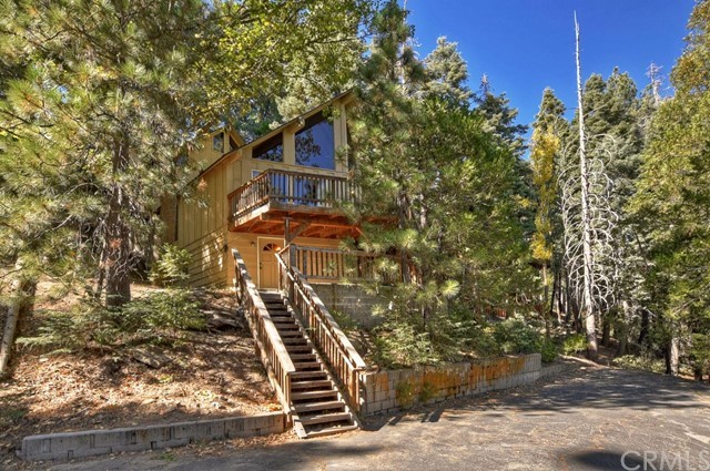 Location Location Location! Full lake rights to private Lake Arrowhead and in the golf course area. This mountain escape offers 2 entertaining living rooms with; 2 story vaulted open beamed ceilings, wood burning stove and stone fireplace! 2 beds/2 full baths, 1,836 sq ft house on a 14,400 sq ft Lot surrounded by tall evergreen trees. Open concept main level living with giant wall of glass looking into the forest. Loft area overlooking the living room below is perfect for kiddo bunk area. 2 lower level bedrooms share a full bath. 2nd full bath conveniently located on main level. Parking area below house plenty big for guests and boat. National forest off road and hiking trails right down the street! Great value, must see!