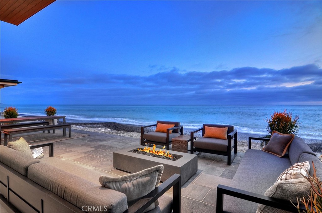 Welcome to the breathtaking panoramic ocean views that surround this rare new construction home “on the sand” in the exclusive gate guarded community of Capistrano Beach. Thoughtfully designed by world renowned architect Chris Brandon and built with the highest quality of craftsmanship by Pinnacle Custom Homes this gorgeous 4000 sq ft soft contemporary is only one of a couple new “on the sand” homes introduced to the So Cal market under $10 million in years. Upon entrance through the custom 10’ glass door, the open floor plan invites you into your great room with a custom etched fireplace and expansive 12 foot sliding glass doors providing direct access to your oceanfront deck overlooking what is truly “private” beach. Step off your deck and put your toes in the sand! The most discriminating chef will love the sleek kitchen with designer appliances including Wolf, Bosch and Subzero, custom oak cabinetry, Absolute Black Granite & ocean-view dining area. Your elegant floating staircase leads to a 2nd floor mezzanine with private Library, Media Room and unobstructed views of the Pacific Ocean. Relax and rejuvenate in your one of a kind 3rd level private Master Bedroom retreat with walnut engineered flooring, private deck and large walk-in closet with Custom walnut built-ins. A spectacular Entertainers Home with the very best in smart home technology featuring Vantage Lighting Control Systems on the most desirable stretch of beach that lets you escape to paradise every day.