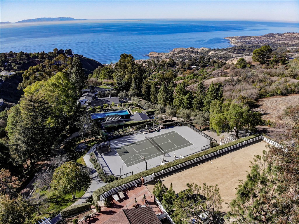 Live on your own seven acre peninsula terraced estate! Situated above the sea on one of the highest points in PV, enjoy the spectacular ocean & Catalina views from every vantage point of this tranquil hideaway. Ten years in the making, this meticulously conceived estate has it all. At the top is an olympic sized riding ring & corral with barn. Next up is the tennis/basketball court with plenty of room for spectators & a built in service area. A wonderful vegetable garden just below. Walk down to the absolutely incredible infinity pool & jacuzzi, a guest house equipped with a full kitchen and large living area which open up to resort like decks & built in barbecue area. Stroll through the private walkways to the main house & into the “zen” garden with lush olive trees & water fountain. The main residence in all its multilayered luxury floats above the sea with expansive Pacific ocean views from Catalina across the PV shoreline. The home features meticulous attention to detail evident with the finest imported Carrera marble and the Tommy Mitchell butterfly chandeliers highlighting the beautiful gourmet kitchen and open living area. Perfect indoor/outdoor living with multiple glass doors opening out to the pristine decks, eating & sitting areas & another jacuzzi overlooking the water. The master suite opens up to the zen garden & features his & hers private bathrooms as well as his & hers offices. Unbelievable design & quality throughout this home. Truly a remarkable property!