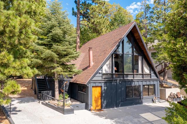 Step into your boho vintage mountain escape. The perfect cabin to host family gatherings and/or garner rental income. With three spacious levels you can be sure to find a warm and cozy nook to sit back and read a book, relax and share some wine by the fireplace or enjoy lake views while dining on the patio.This home offers an upgraded 200 amp electrical panel, custom painted black cabin exterior, original hardwood floors, new quartz kitchen countertop, new dishwasher, new Kohler sink and faucets, \new light fixtures, window coverings, custom wood blinds and a new custom L shaped storage bench and dining table (option to purchase furniture). And if that wasn't enough, the location is optimal! Only a 3 minute walk to the lake and minutes away from the marina!