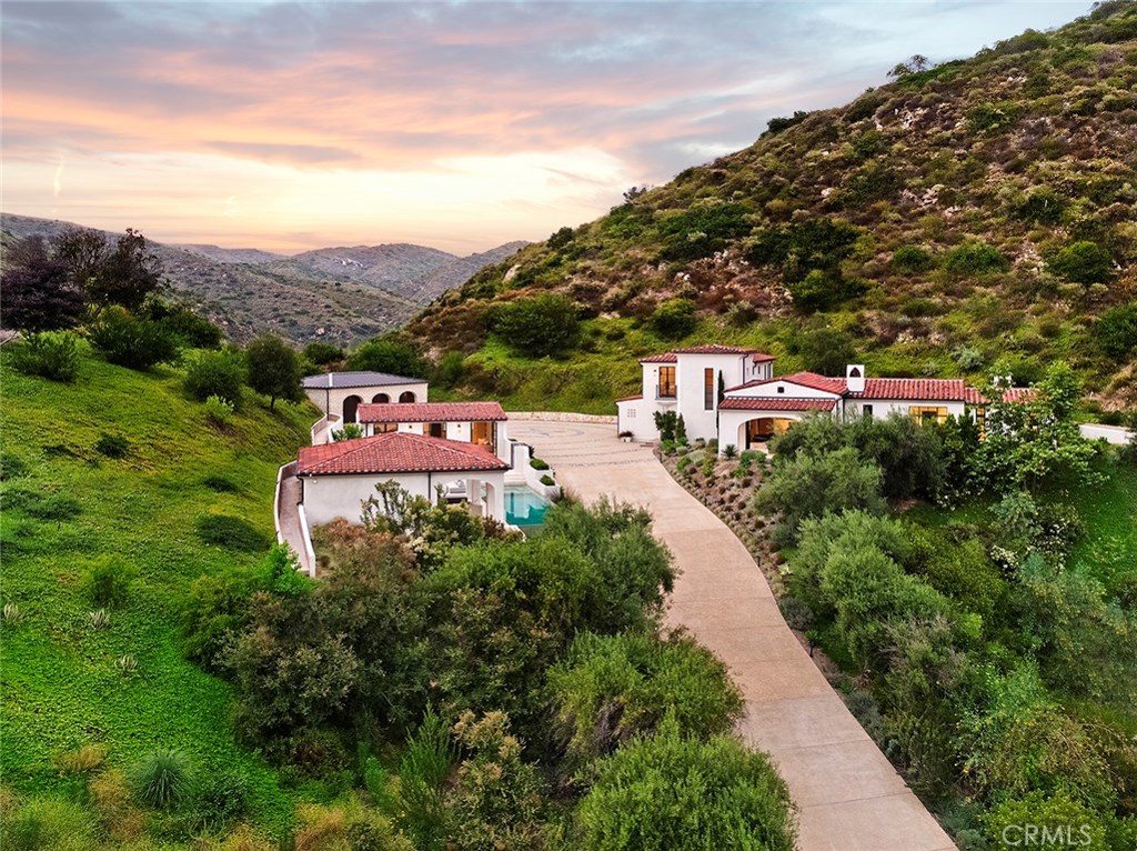 Peace and tranquility flow from this one of a kind Malibu-style estate, which combines breathtaking views and unparalleled privacy &#8211; all surrounded by 6 acres of natural beauty in the hills of Laguna Beach. Through a private gated entry, the long driveway leads to a motorcourt with 4 separate structures: the main residence plus a 3 car garage, a guest house, a pool house, & an additional 4+ car garage. With inspiration drawn from architectural legends Wallace Neff and George Washington Smith, each timeless element builds upon another, coalescing into a modern work of art that pays homage to its exquisite heritage. An air of sophistication permeates every interior space, where each material, detail, & finish has been pored over hand-selected for its precise influence on the delicately balanced design. Walls of white Venetian plaster, white European oak hardwood flooring, & dramatic vaulted ceilings with exposed beams clothe each room in timeless elegance. The home&#8217;s unique form and function make it exceptional for any task, whether that be a quiet, solitary weekend of relaxation & mindfulness or a summer soiree with guests enjoying the Bora Bora-inspired infinity & zero-edge lap pool. The estate&#8217;s state-of-the-art amenities, surrounding natural beauty, & utmost privacy place it in a league of its own, establishing a new caliber of excellence. Convenience complements privacy, as the estate is located only 10 minutes from major freeways & the picturesque beaches of Laguna Beach