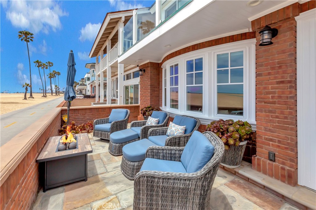 **Price IMPROVEment** Nestled on an oversized corner lot, this magnificent two-story home offers a relaxed oceanfront living experience. Located in the heart of the Balboa Peninsula with its breathtaking panoramic views of the Pacific Ocean. Enter through the dutch door to an open floor plan that includes a family room, bay windows, fireplace, dinning area with cofferd ceiling and a bright functional kitchen. Off the kitchen is a main level bedroom, two bathrooms, and laundry area. Step down into the great room with beamed ceilings, fireplace, an abundance of storage space. Large sliding glass doors open to a very private enclosed side patio, perfect for pets to roam freely. Attached is an oversized two car garage, next to the garage behind the double door access gate gives way for a third auto. The second level consists of three bedrooms, two baths, a walk in closet, and a balcony off two of the bedrooms overlooking the boardwalk and blue sea. Asend up the third staircase to the roof top with a gas fireplace, countertops, a refrigerator, spot for a bbq, storage, and 360 degree sweeping views from Newport Coast to Catalina. Over the years, there has been upgrades and additions from the exterior to the interior leaving the quintessential character of the costal chic original build.