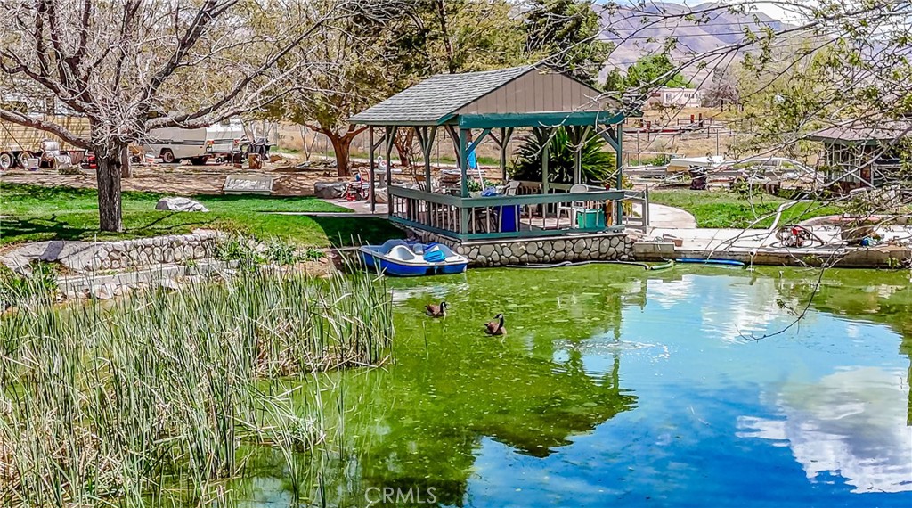 FAMILY COMPLEX!! Main house with 5 separate ADU’s!! Private Lake with Island & rock waterfall, Movie Theater Complex, and much more!! An excellent property for a very large family! Could be also great property to do Airbnb, Bed & Breakfast, or any Home-Based Businesses. Very large main home with 4 bedrooms, 3 bathrooms, 5,012 Square Feet of spacious living space. Grand entryway into the foyer and huge real rock grand fireplace. Open concept with a split floor plan. The south wing of the home includes the living room, beautiful kitchen with ample cabinet space and granite countertops, the kitchen opens up into the oversized dining room with a 2nd fireplace, 2 other bedrooms and 2 full bathrooms. The north wing offers oversized laundry room/office which could be utilized as a bedroom, and the 3rd bathroom has a bathtub. The large Primary suite includes a beautiful bathroom with walk-in shower, soaking tub, his/her vanity sink with granite counter tops. The 3rd fireplace is located master suite’s bedroom. A HUGE 1200 Square feet Hall Room with pellet stove, which is great for meetings, large gatherings and entertaining. Inground POOL! Backyard has a gorgeous huge pond stocked Koi fish and Catfish, surrounded by a well maintained lawn, mature trees, back porches and carports. ADU 1 bedroom and 1.5 bathroom. ADU 2, 3, 4, & 5 has 1 bedroom and 1 bath each. Large 4.24 acre of land is completely fenced with block wall and larger wrought iron gates!! A 1 OF A KIND PROPERTY RARE PROPERTY!! Must come to see the entire complex to truly understand the possibilities!!