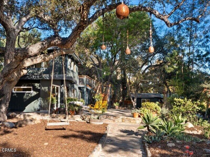 Love is in the Air! Quintessential Ojai living radiates from this enchanting East End property off Thacher Road on the delightfully named Happy Lane. Happy indeed ~ Spanning on an acre, this private mini-compound is a blissful fusion of lush beauty, shaded by mature canopy trees and filled with artistic inspiration. The main house offers two bedrooms, a converted office serving as a third bedroom, and a bathroom. Upstairs, the separate Junior ADU charms with one bedroom, one bath, and a spacious, treehouse-like terrace perfect for stargazing or unwinding with stunning views. Creative spaces abound, from the art studio and writer's office to the cozy chill cabin and outdoor showers, all complemented by an infinity cedar redwood tub. The grounds are an entertainer's dream, featuring a fire pit, yoga platform, rock walls, and former tortoise sanctuary, blending rustic charm with serene tranquility. Your guests will feel home in the chic and cool Airstream, set amidst the enchanting landscape. Ideal as a primary residence or a tranquil pied-a-terre, this bohemian haven embodies Ojai's laid-back, artistic lifestyle, surrounded by nature and conveniently close to top schools, hiking trails, and mountain adventures. This is Ojai living at its best!