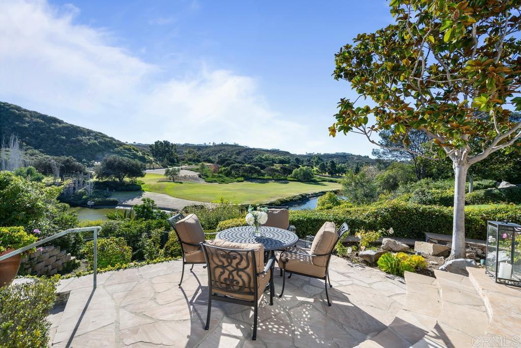 Premium view lot with southern exposure on the 9th hole of the prestigious Del Mar Country Club. Imagine a beautiful English garden home with stone entry welcoming you past soothing water features and manicured gardens privately set above the golf course. Upon entering, you will discover wide-plank oak flooring leading into the great room with vaulted beam ceilings complete with serving bar and entertainment center gracing both sides of the custom fireplace. The many doors of glass provide a breathtaking outlook onto the lush fairways, lakes, and rolling greens. This classic 4+ bedroom home has been beautifully remodeled throughout while still holding onto its French charm. The gourmet Kitchen enjoys a sunny breakfast nook, formal dining room with adjacent chilled wine room, naturally lit primary suite with vaulted ceiling, floor to ceiling windows, dual baths and closets, an expansive deck with stunning golf views, and an oversized bonus room. The covered outdoor living area encourages relaxation next to the fireplace, swimming in the gleaming pool/spa or enticement to hit the links. 3+ car garage with golf cart parking. Other amenities include the following: Brand new roof, pool equipment, Solar panels, air conditioning units and furnaces, tankless water heater and LED lighting throughout. Steps to Clubhouse to enjoy dining, tennis, pickle ball, fitness center, and the championship golf course. Do not miss out on the chance to own one of the best lots in DMCC.