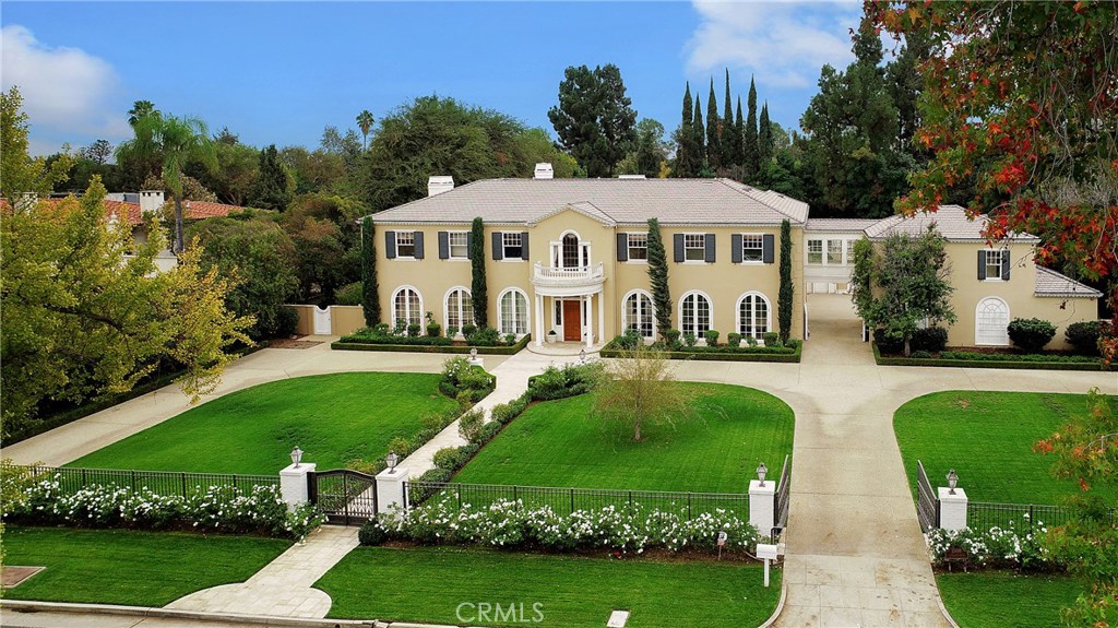 Livable luxury is what you will attain at this expansive Colonial Revival residence on exclusive Lombardy Road. Located in the prestigious Huntington Library area of Pasadena, meticulous attention is given to all elements, making this house feel like a home, even at this caliber. Upon entry, an upward gaze treats your eyes to the tall foyer, sweeping staircase, and masterfully precise and skillfully executed details. Soft, yellow tones bring a cheerful sensation, inviting you for a stroll to the family room ahead. A beautifully crafted fireplace serves as the focal point, and the highly detailed coffered ceiling adds visual structure for you and your guests to enjoy at every glance. Fine woodworking throughout and mahogany graces the floors for a timeless touch. The living room offers upscale elegance with room for a grand piano, and large windows framing the fireplace, illuminating the entire room with natural light. The master suite is a showplace with 2 master closets and 2 master bathrooms - her master bath featuring a well-appointed soaking tub, separate shower, picture window and in-closet laundry. The master loggia overlooks the swimming pool and extremely private backyard below. Other features of this estate are a separate guesthouse perfect for game nights. It also has a private gym. The home has a gated entry, elevator, sound system, three-car garage, and a private motor court. Come see how you can elevate your luxury living to a whole new level on Lombardy Road!