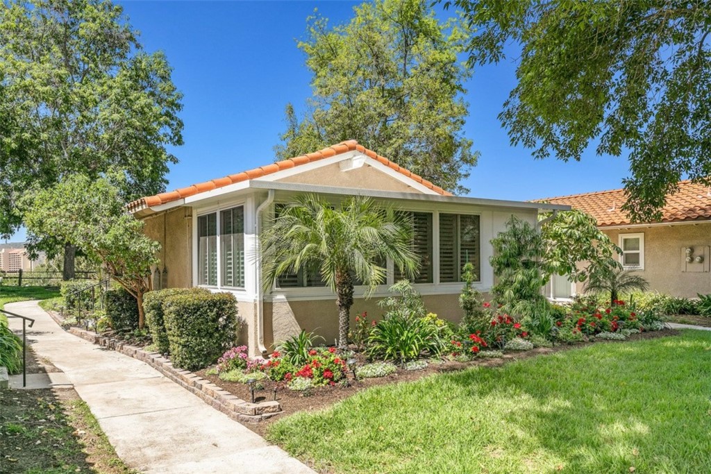 PRIVACY and CITY VIEWS in a prime Laguna Woods Village location! Two bedroom/two bath condo situated within one of the highest elevations in the Village! You will relish the city light views from two perspectives, plus a private corner mesa of your own and English garden-look landscaping. The kitchen has newer windows, QUARTZ COUNTERS, custom cabinets, water filtration system, recessed lights, stainless fridge, Samsung appliances and newer faucet. Dining room with wine cabinet included has quality custom built cabinetry. Living room opens to a custom enclosed (city and HOA permitted) PATIO ROOM (with new concrete and rebar foundation), adding 300 square feet to the property. Patio room has ELEGANT CUSTOM PLANTATION SHUTTERS (lifetime warranty), recessed lighting and a portable electric FIREPLACE with mantel, creating the perfect media room. Here you can relax and gaze through the window at the moonlit sky to add to your peaceful enjoyment of this enchanting home! Inside laundry hook-ups for stackable washer and dryer hidden by a custom made louver door. The master bedroom has new CUSTOM CABINETS added, including a BUILT-IN WARDROBE, tall new MIRROR CLOSET SLIDERS, new ceiling fan and electrical outlet. The en suite master bath has a GORGEOUS QUARTZ SLAB and custom cabinets, plus new finish bathtub, fixtures and GLASS BATHTUB DIVIDER for an upscale feel. New hardware throughout!!! The guest bedroom has a spectacular view of the small park outside the home. Custom deep storage cabinets have been added. The guest bathroom has newer cabinetry, Renu shower finish and a SUBWAY TILE WALL; creating an updated touch to complement the bath cabinets and countertops. The interior has been painted with Dunn-Edwards superior paints, and the property has NEW WATERPROOF PLANK FLOORING with a lifetime warranty. This quality home is built to last and enjoy for years to come. Air conditioning system was just given annual check-up and all smoke alarms in the house are new with a 10 year warranty. Don't miss this unique and very special property -- it's a rare find! Resort style 55+ living with 27 hole championship golf course, 7 clubhouses, 5 pools, 3 fitness centers, wood and metal shops, arts and crafts, tennis, pickleball courts, stables and over 250 clubs plus transportation system.