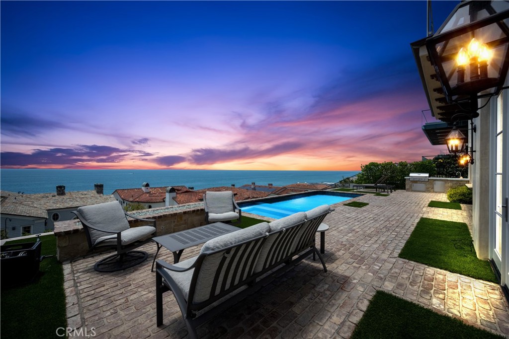 Welcome to this luxurious custom residence located in the elite community of The Strand at Headlands surrounded by the stunning beauty of the Pacific Ocean. Sitting atop one of the highest points of the North section of the guard-gated enclave; a single-loaded cul-de-sac filled with six premier homes. Upon entry, you will be mesmerized by the sit-down ocean panoramas that create a relaxed coastal ambiance on both levels. A sizeable great room that opens to dining areas, bar and a gourmet kitchen with spa-inspired Carrera marble countertops and top-of-the-line Viking appliances. Conveniently open the pocket doors to marry the indoors with a covered portico featuring built-in heaters and TV centre perfect for effortless entertaining. Out on the vast patio, you will find a pool/spa, fire pit, and built-in BBQ all with phenomenal views of the Pacific Ocean, Dana Point Headlands and Catalina Island. The lower level encompasses a library/office, guest bedroom with en suite bath, as well as access to a subterranean wine cellar. The upper level offers three bedrooms, including an expansive primary suite with a private balcony, spa-worthy bath, and dual walk-in closets. Designed and crafted by renowned builder Richard Doan, this spacious and bright home boasts luxurious high-end finishes including European White Oak plank floors, precision millwork, antiqued brick accents, and lavish wainscoting. Other features of this property include a state-of-the-art Crestron A/V system, substantial garage parking for 3 vehicles plus a golf cart, as well as a private floor-to-ceiling locker at the beachfront Strand Beach Club with exclusive resort-style amenities for residents. Don't miss this incredible opportunity to experience the ultimate oceanfront living in this stunning property. Take a tour today and experience all that 41 Beach View Avenue has to offer!