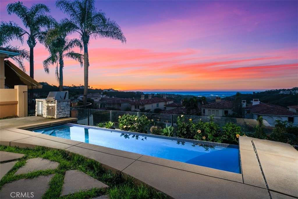 Nestled within the esteemed community of Santa Lucia in Newport Coast, 5 Torrey Pine, once the model home for this exclusive neighborhood, stands as a testament to luxury living. This 4 bedroom, 4.5 bath residence occupies a prime location on one of the finest view lots, offering unparalleled ocean and harbor vistas. The grandeur of the main level is immediately evident, featuring soaring ceilings that amplify the sense of space and elegance. This level encompasses formal living and dining rooms, creating an ideal setting for hosting gatherings and entertaining guests. The family room seamlessly connects to the well-appointed kitchen and charming breakfast nook, providing a comfortable and inviting space for daily living. Each of the four bedrooms within this residence is a private haven, boasting its own en-suite bathroom for the utmost convenience and privacy. The primary bedroom is a true retreat, accentuated by an adjoining sitting room that captures panoramic ocean and harbor views, creating a tranquil and inspiring sanctuary. The versatility of the main floor bedroom adds an extra layer of functionality, serving perfectly as a home office for those seeking the convenience of a work-at-home space. The thoughtful layout and design cater to modern lifestyles while maintaining an air of sophistication.Embrace the California lifestyle outdoors on the expansive lot, perfect for entertaining guests. The infinity edge pool invites you to unwind while enjoying the captivating views, and the built-in barbecue area adds a touch of luxury to al fresco dining experiences. 5 Torrey Pine is not just a residence; it's a statement of refined living in one of Newport Coast's most desirable communities.