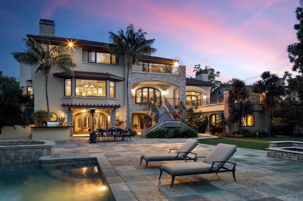 Luxurious 8,000 square foot gated La Jolla estate situated on a flat half acre of land in the heart of the Muirlands neighborhood! Extensively remodeled in 2015, this meticulously crafted turnkey three level residence offers a Rancho Santa Fe setting on one of the most desirable streets in prestigious La Jolla. Partial ocean views, a large pool with adjacent lap pool and spa, custom putting green, fire pit and multiple outdoor entertainment features are among the endless amenities you’ll enjoy with this exquisitely updated home. The upper level boasts four bedroom suites, including a large master suite with a sitting area and its own balcony that offers ocean views and a massive walk-in closet. The expansive lower level is the ultimate in entertainment, complete with home theater, billiards, custom bar, sauna, game/massage room, temperature-controlled 1,100 bottle wine cellar, and mirrored gym (optional 6th bedroom). The attached guest quarters has its own bath and private entrance. Other highlights include a grand open-island kitchen with premier stainless appliances and stunning white Calacatta marble counters. High ceilings and large windows throughout provide stateliness to this ideal La Jolla home.