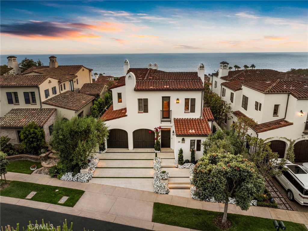 Experience the breathtaking beauty of this Crystal Cove home, where bold ocean views offer panoramic vistas and vibrant sunsets. A recent renovation directed by famed local designer, Brooke Wagner, offers unmatched quality and style throughout approximately 4,000 s.f. of sun-drenched living space. The floor plan includes 4 bedrooms and 5 bathrooms including a separate guest casita with private access and patio with tranquil water feature. White oak floors throughout the main living areas bring warmth to airy spaces, including an open-concept living room with a marble-clad fireplace and folding La Cantina doors that frame mesmerizing ocean views through a covered sitting area. An island with bar seating is the centerpiece of an incredible kitchen, where thick marble countertops offer timeless style and top-line appliances include a 6-burner range w/grill, double ovens, and a paneled refrigerator. A large butler's station with a built-in wine 75-bottle wine refrigerator and spacious walk-in pantry completes the kitchen space. The dining room looks out toward the stunning Pacific Ocean, offering views that become an ever-evolving art piece. On the upper floor, enviable views are found in an extraordinary primary suite, with a view balcony and two exquisite walk-in closets offering custom storage. The ensuite is filled with carefully considered details including stunning statement lighting, designer wallpaper, hammered copper sinks, and a sleek modern soaking tub. Two additional bedroom suites, with custom closets and bathrooms that feature on-trend yet timeless style. A bonus/media room also features an ocean-facing balcony, as well as built-in cabinetry, and a separate workspace. Perched on a blufftop with dramatic ocean views, outdoor areas rival the vibes of a luxe boutique resort, with a sparkling zero-edge pool and spa looking out over the Newport coastline. A loggia offers a shaded area that connects to the house, a BBQ kitchen, and multiple lounge areas provide sun-drenched seating spaces. Additional upgrades include a 2.5 car garage (with built-in ceiling heater and additional refrigeration) and whole-house home automation. The enclave of Crystal Cove has 24-hr guard-gated security and unmatched amenities: resident-only access to The Canyon Club, as well as direct access to Crystal Cove State Park and Beach, and proximity to private parks, hiking and biking trails and upscale shopping & dining at the Crystal Cove Promenade.