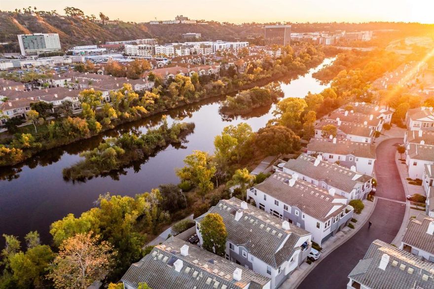 Rarely available South facing end unit overlooking the San Diego River! Peacefully situated in the gated community of Union Square in the heart of Mission Valley, this immaculate townhome offers privacy & comfortable sophistication w/ its refined open interior, contemporary design elements & the only Model 2 unit in the complex w/ private view balcony off the primary suite. Quintessential location: Steps to Hazard Center & shopping centers w/ a conveniently located Trolley stop & easy freeway access to the beaches, downtown, & airport all while maintaining privacy & exclusivity. Once inside, crown molding, luxury vinyl floors & new windows throughout work to create a captivating interior offering a spacious high-end feel. Bathed in natural light & accented w/ high ceilings, beautiful stained glass windows & an elegant electric fireplace, the spacious living room & adjacent dining room offers a perfect balance for casual lounging or hosting elevated gatherings alike while sliding glass doors work to unite the interior to the private outdoor patio. Remodeled kitchen equipped w/ granite counters, white shaker style cabinetry, instant hot water faucet, island & walk-in pantry. Mainl-level half BA. Continue upstairs w/ gorgeous wainscoting. Affording the timeless charm of sunset views, the primary suite features a large balcony, tray ceilings, plantation shutters, California closets and folding closet door to maximize space. Spa quality BA w/ dual sinks & walk-in shower. Secondary BR w/ crown molding & upgraded ensuite BA. Both BRs feature new ceiling fans. Attached 1 car garage w/ resurfaced floors. 1 assigned parking space. Backyard offers a perfect balance of beauty & function w/ irrigation system, dusk to dawn LED lighting & pergola. Welcome home!