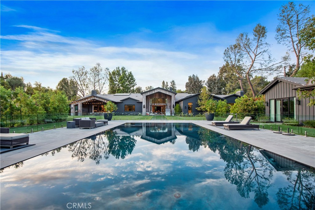 Absolutely stunning newer contemporary farmhouse on an epic nearly 2 acre usable lot in guard gated Hidden Hills. A sensational and unique single story floorplan with a subterranean gym and 10+ car garage. Designed and built with the finest finishes and craftsmanship! Interior features include a grand two story entry, state of the art theater, formal office/library, and a striking open concept double island kitchen/ family room. The massive resort quality grounds are second to none! There is a detached guest house, custom zero edge pool, professional gardens, firepits, water features, tremendous manicured lawns and beautiful mountain views! other amenities include a smart home system, elite camera/security, vanishing pocket doors, custom detailed walls and ceilings, deep setback circular driveway and much more. One of Hidden Hill's finest estates!