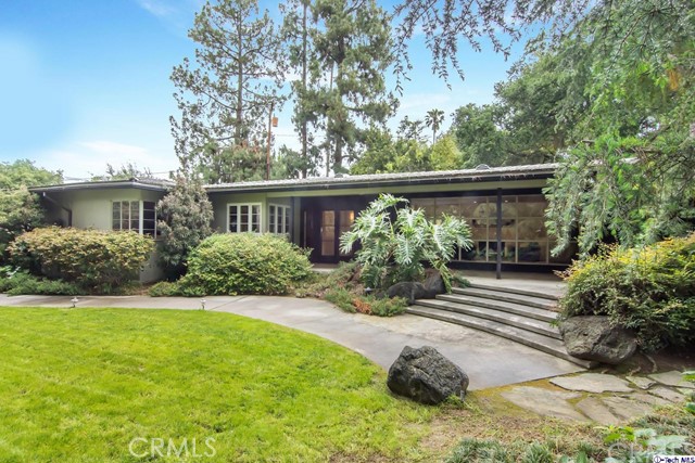 This 1950's Mid-Century modern retreat is tucked away in the distinguished Flintridge neighborhood of La Canada. A rare opportunity to own a single story architectural gem offering clean lines, walls of windows and a truly open floor plan. The home was remodeled within the last 5 years with much consideration and no amenity was overlooked. An oversized living room welcomes you into the home and features a gorgeous fireplace and a fabulous wall of windows. A truly family friendly family room is expansive with built-in bookshelves and wonderful natural light from the abundance of windows. 3 bedrooms are situated on one wing of the home as well as a spacious and modern bathroom. The other wing of the home has an oversized en-suite bedroom. The home has gorgeous hardwood floors, recessed lighting and a 2-car attached garage. A sliding door from the living room brings you outside for true California living. Relax on the deck or enjoy the peacefulness of living on a private cul-de-sac. This home sits on .67 acres of land with lush custom landscaping and plenty of extra parking.